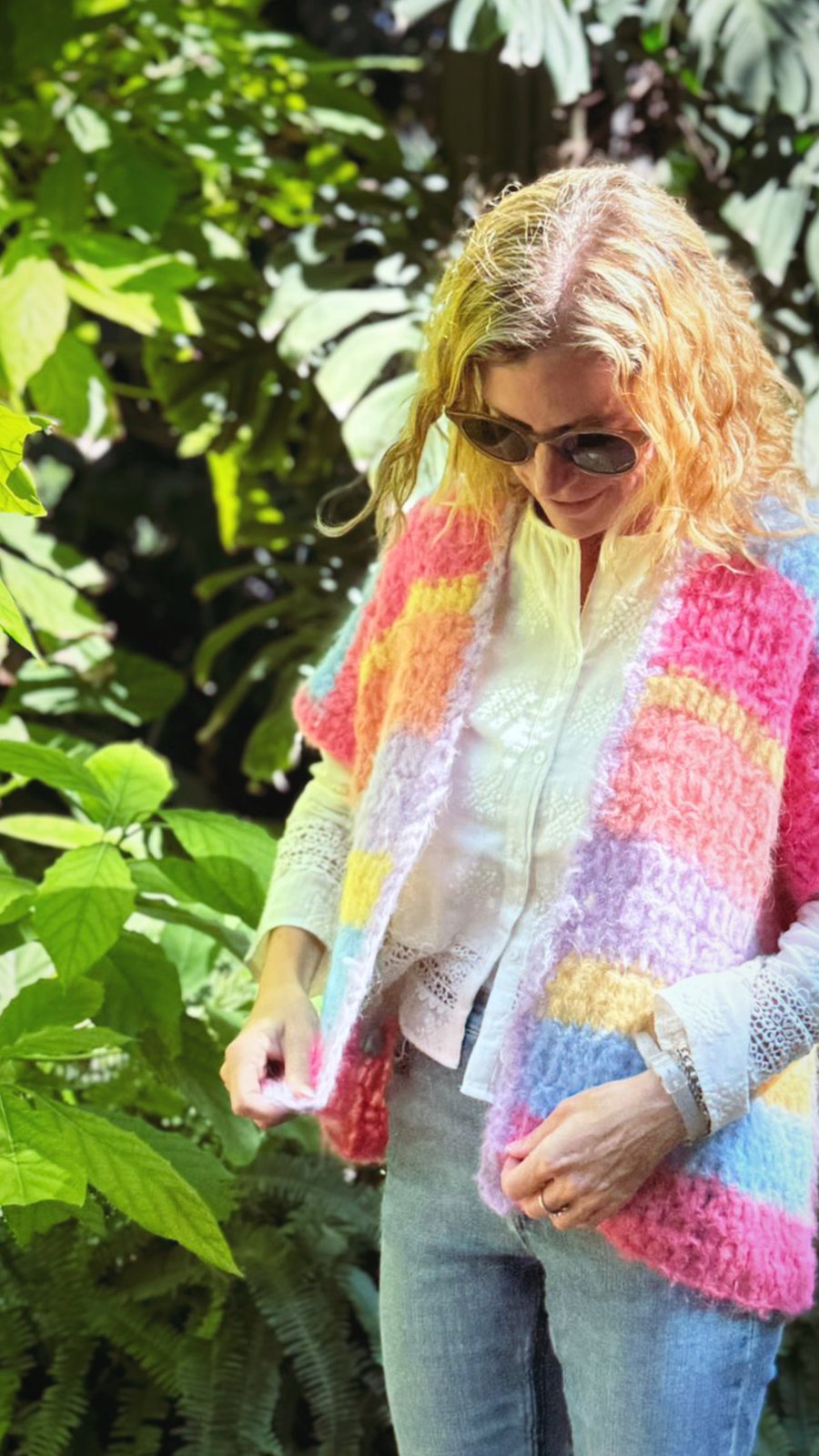 Trini en el jardín con su chaleco de crochet en tonos arcoíris