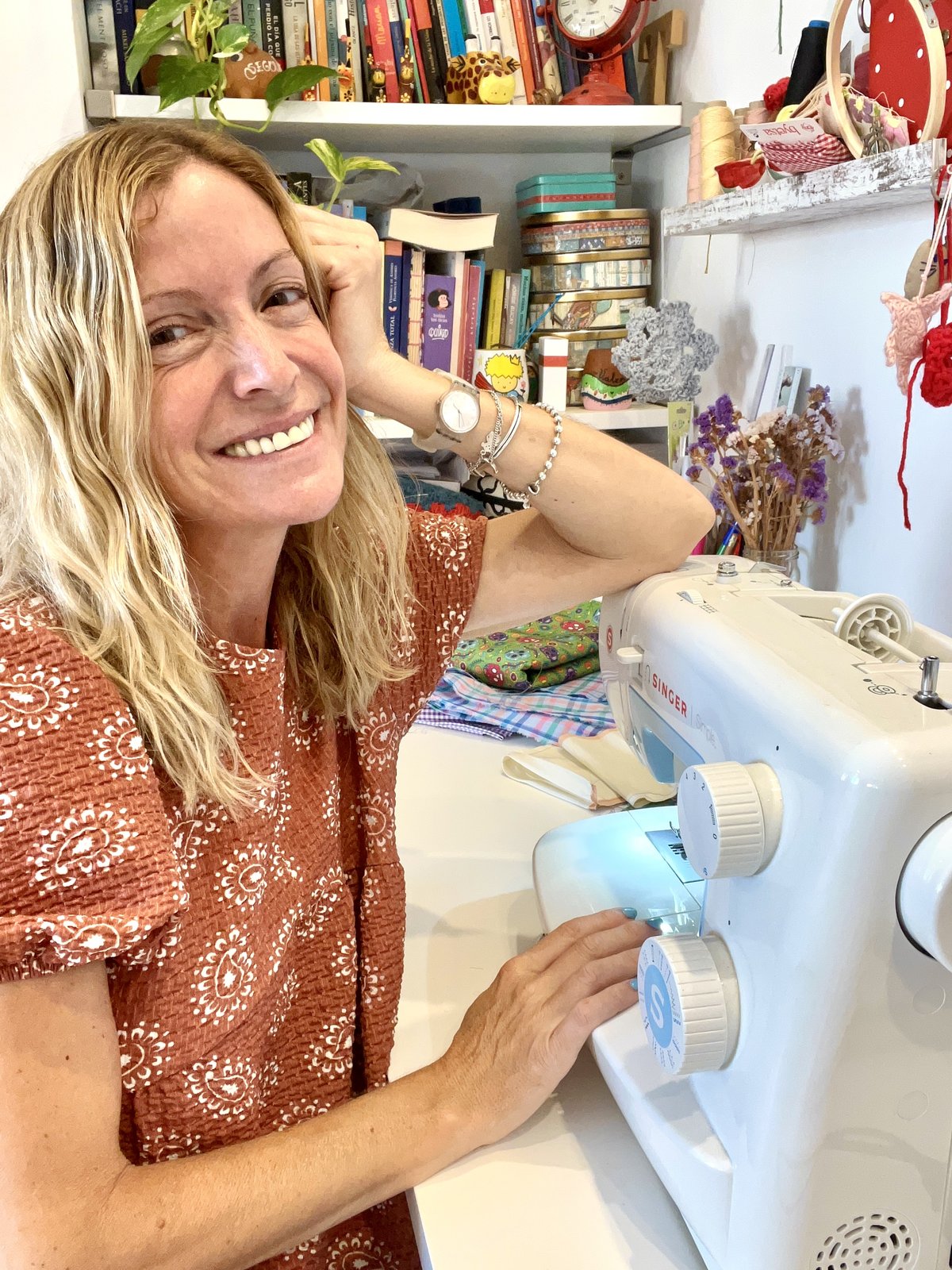 Trini sonriendo junto a su máquina de coser