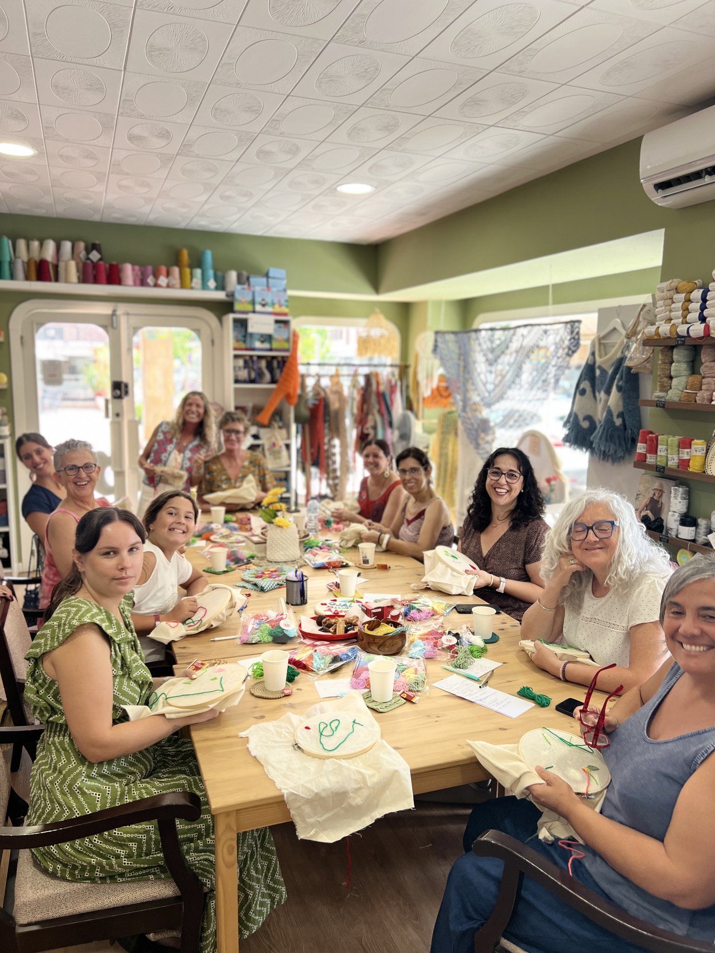 Mesa de mujeres bordando juntas sus bolsas en un taller