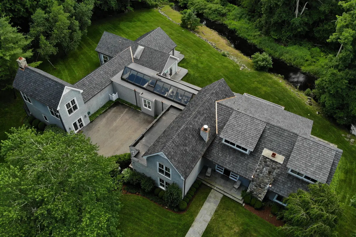 Aerial view of a Brava composite cedar shake roof on a wooded estate property