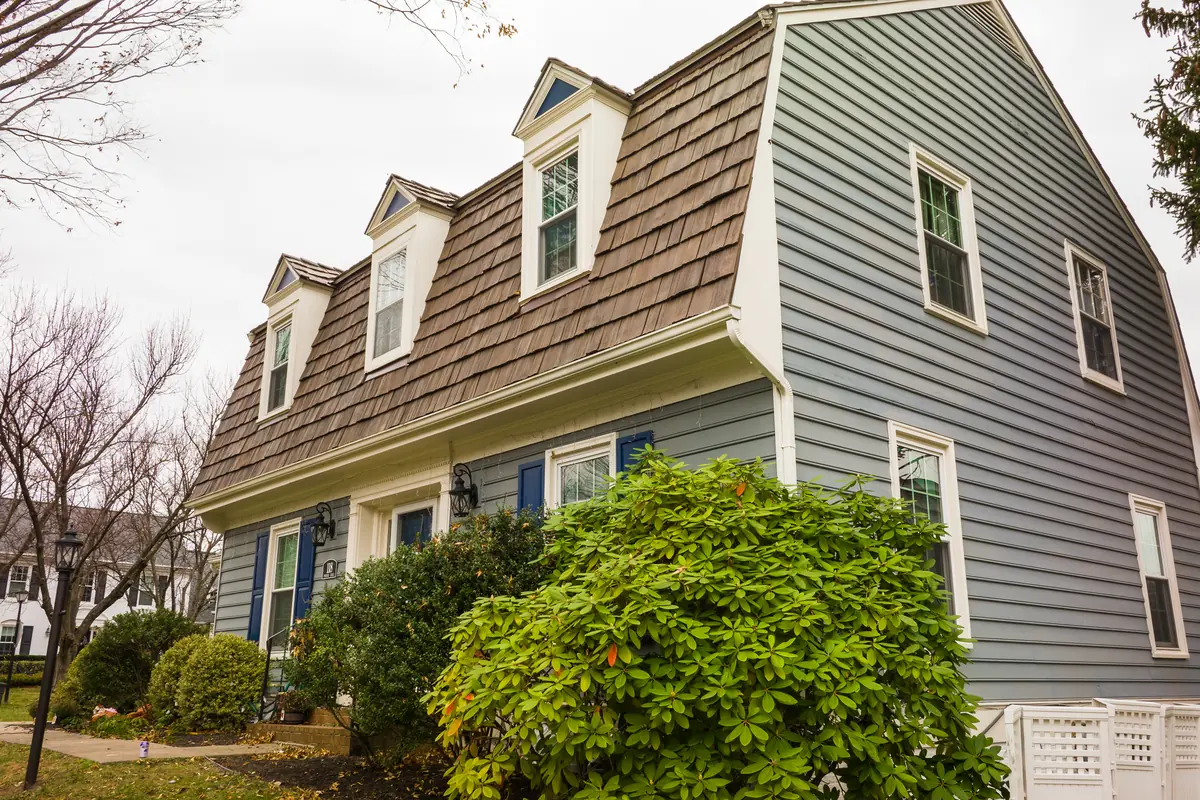 Brava composite cedar shake roof on a gambrel-roofed home with shed dormers