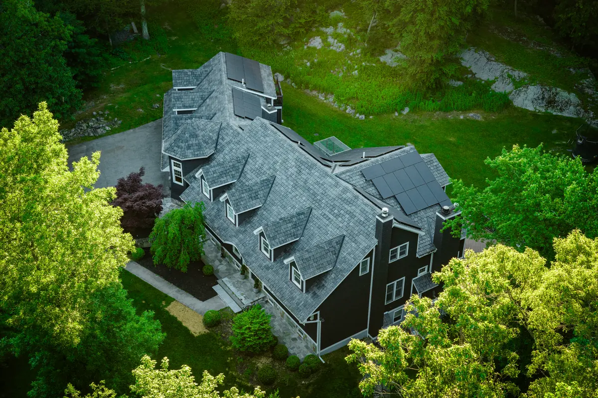 Brava synthetic slate roof on a traditional home surrounded by mature trees