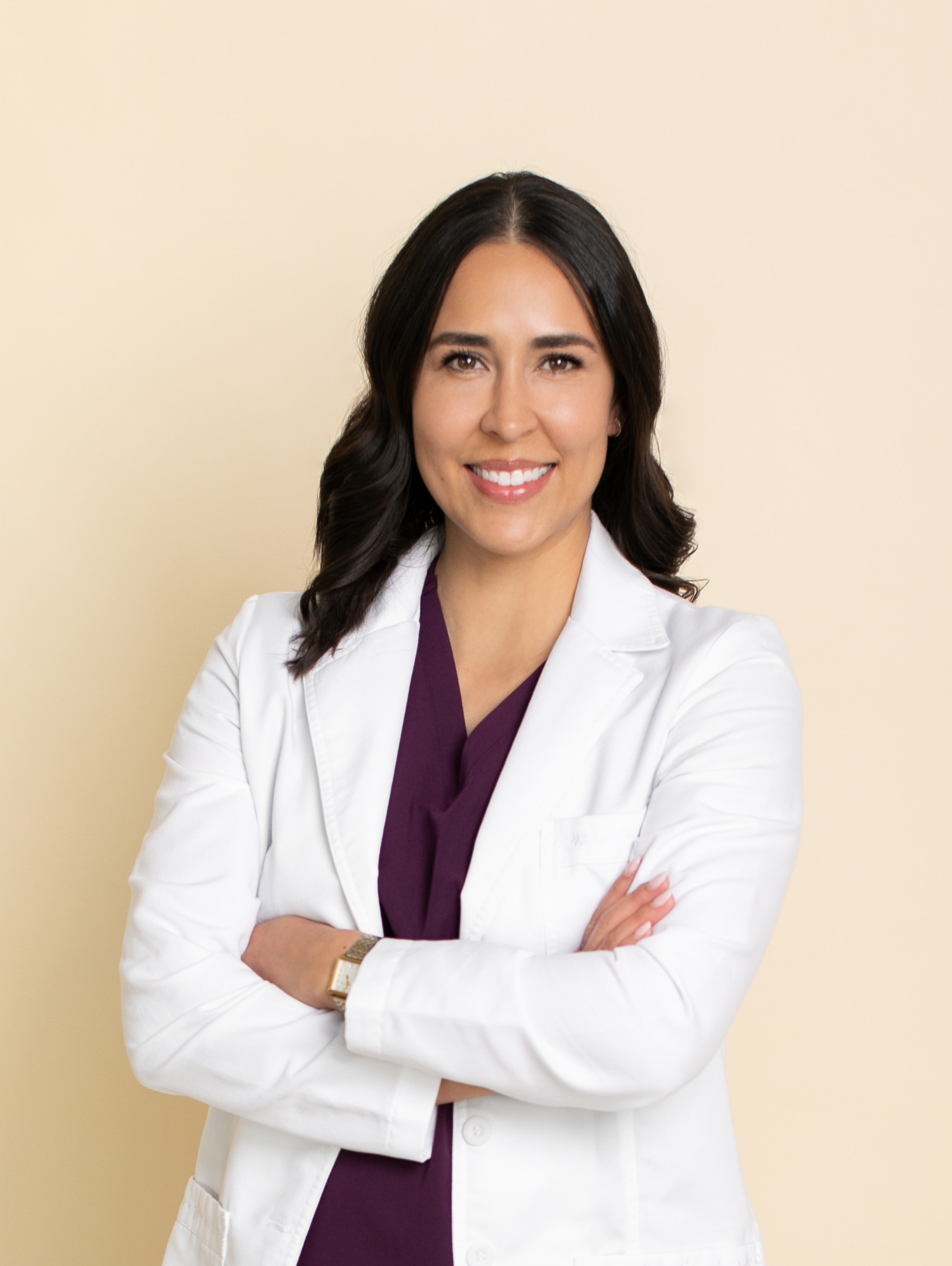 Marisa Martin smiling with her arms crossed in a white coat