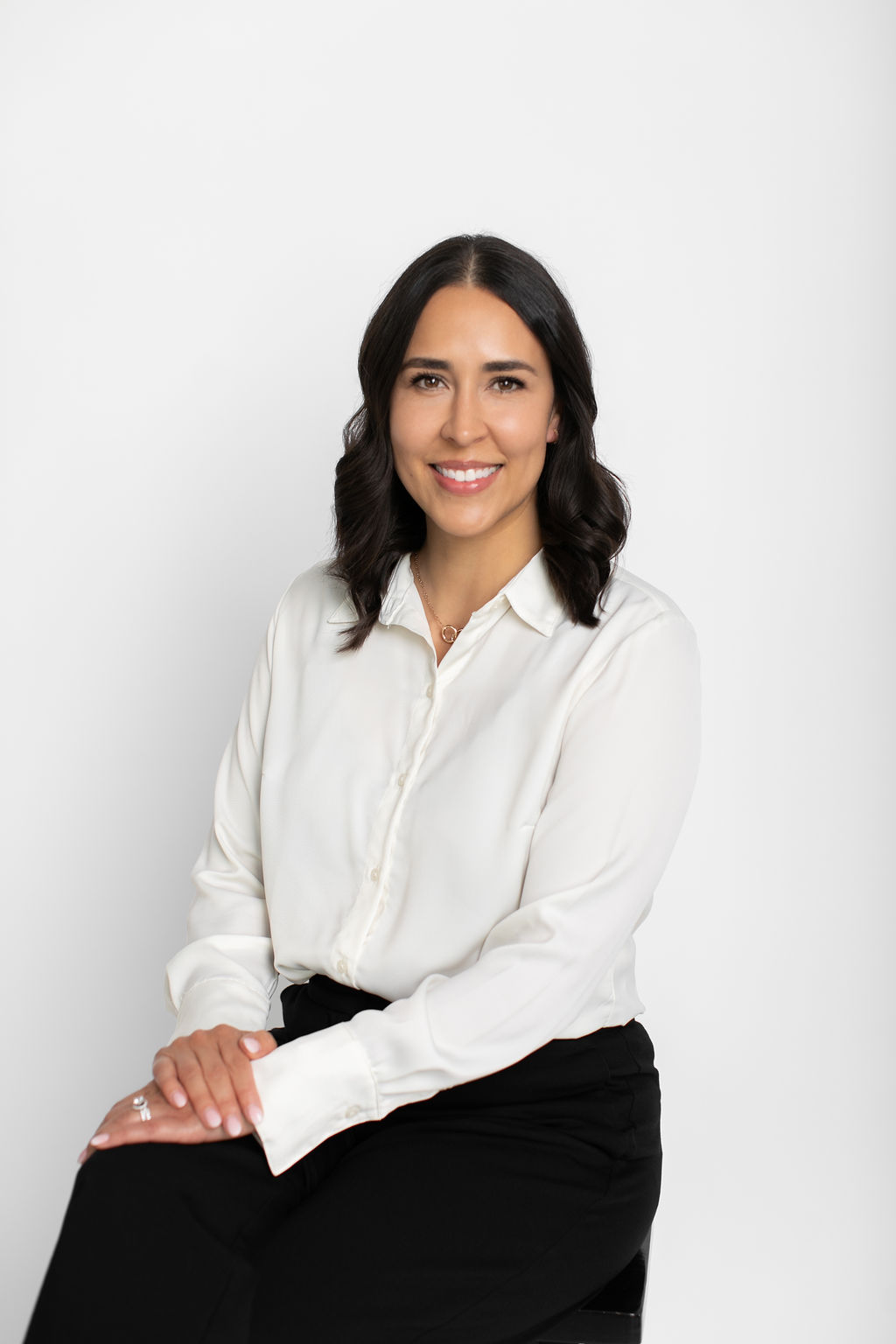 Marisa Martin seated and smiling in a white blouse