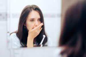 Woman holding her cheek after dental treatment Woman holding her cheek after dental treatment