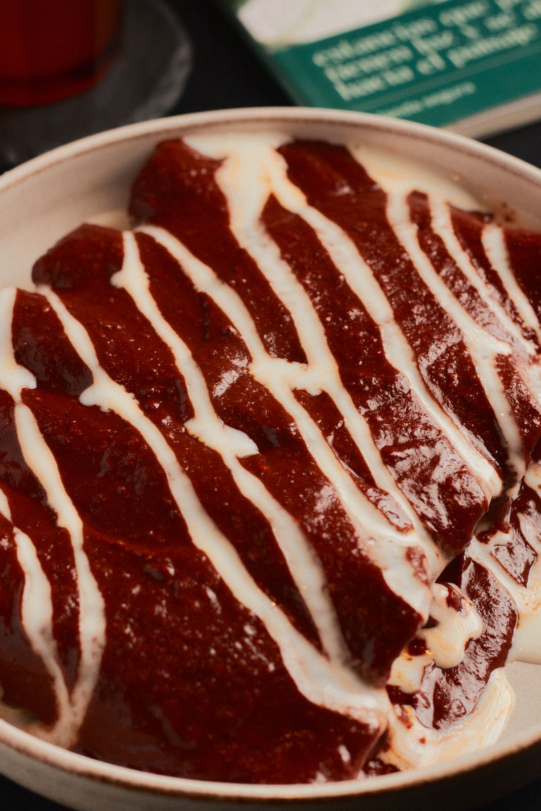 Enmoladas Liminal bañadas en mole con crema