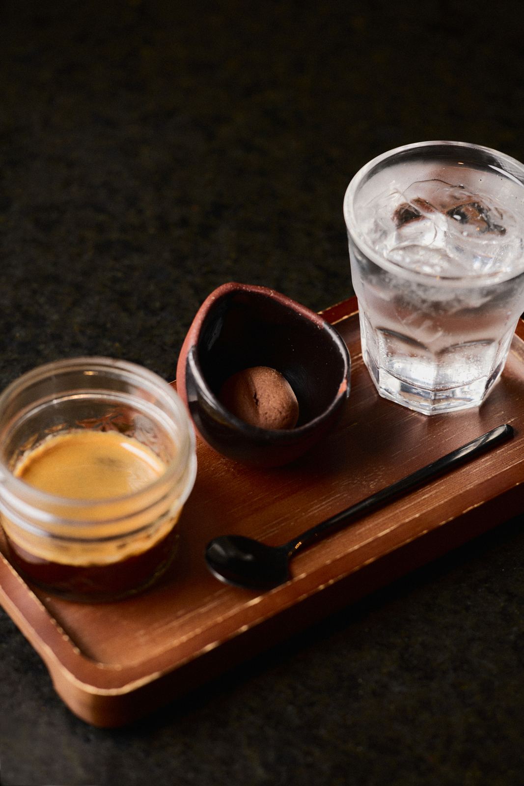 Espresso servido en charola de madera con agua mineral