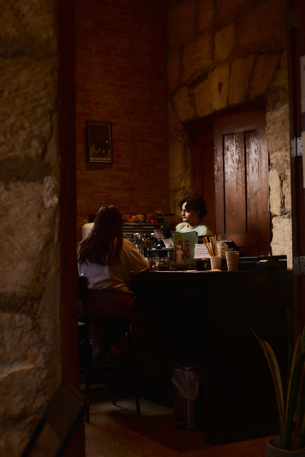 La barra de Liminal con clientes y la puerta de madera