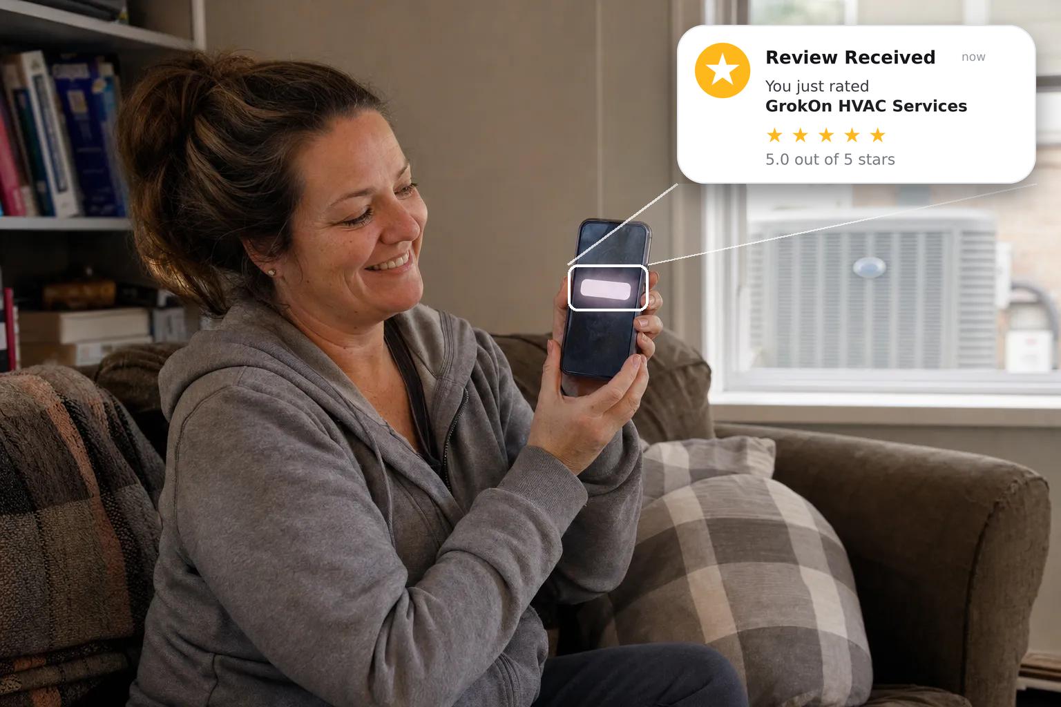 A person sitting on their couch, phone in hand, mid-smile while looking at the screen, freshly finished home service work visible in the background A person sitting on their couch, phone in hand, mid-smile while looking at the screen, freshly finished home service work visible in the background
