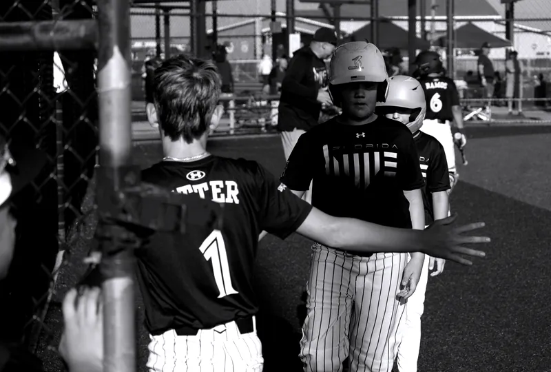 Owen Etter high-fives teammates at the fence