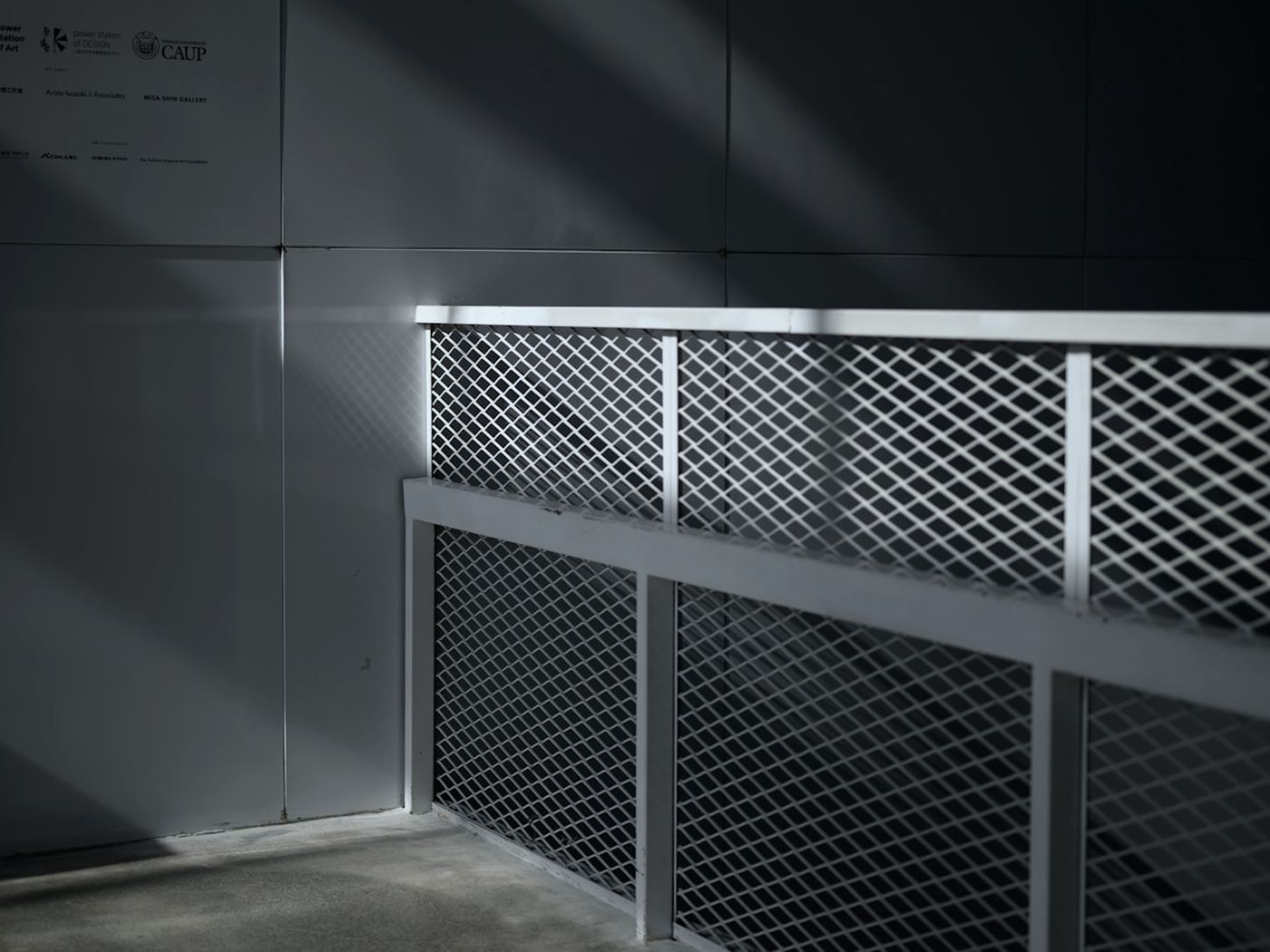 Mesh steel railing against a grey wall