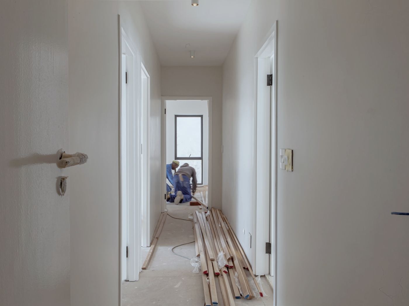 Hallway mid-renovation with new doors and lumber