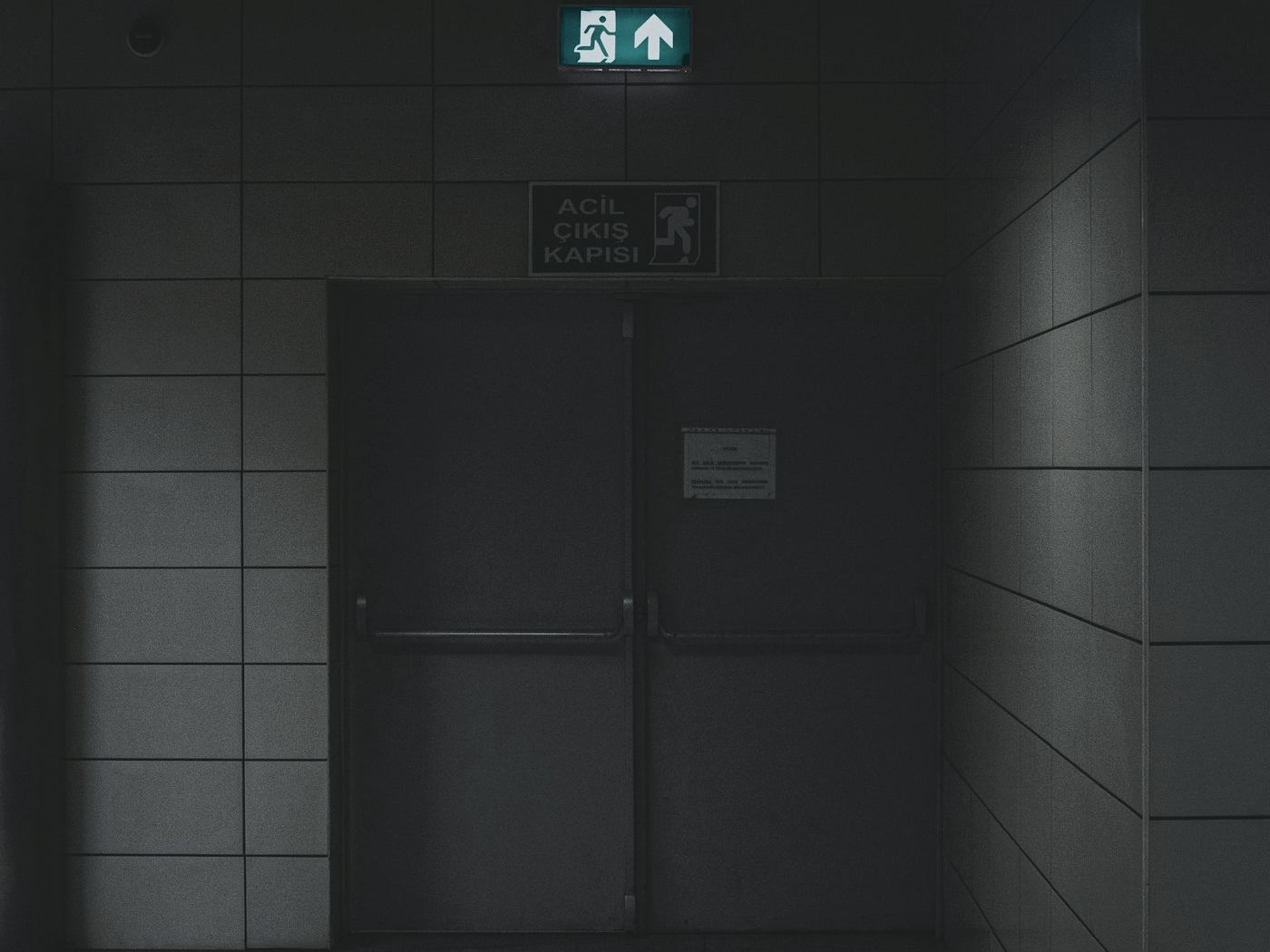 Grey steel double doors under an exit sign