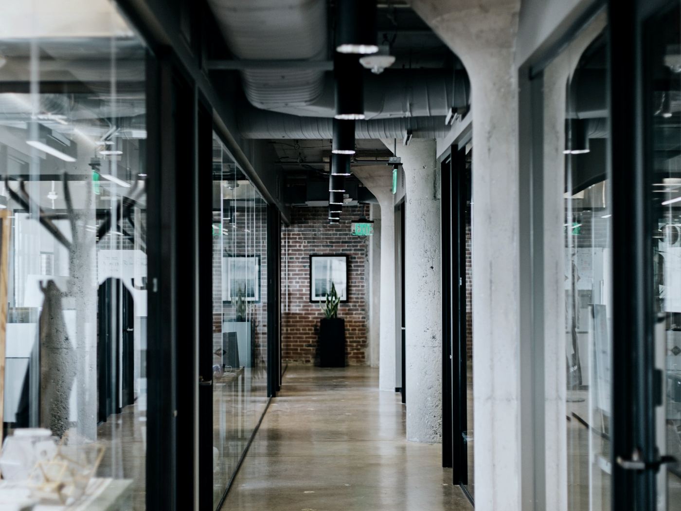 Office corridor with glass partitions and exposed ceiling