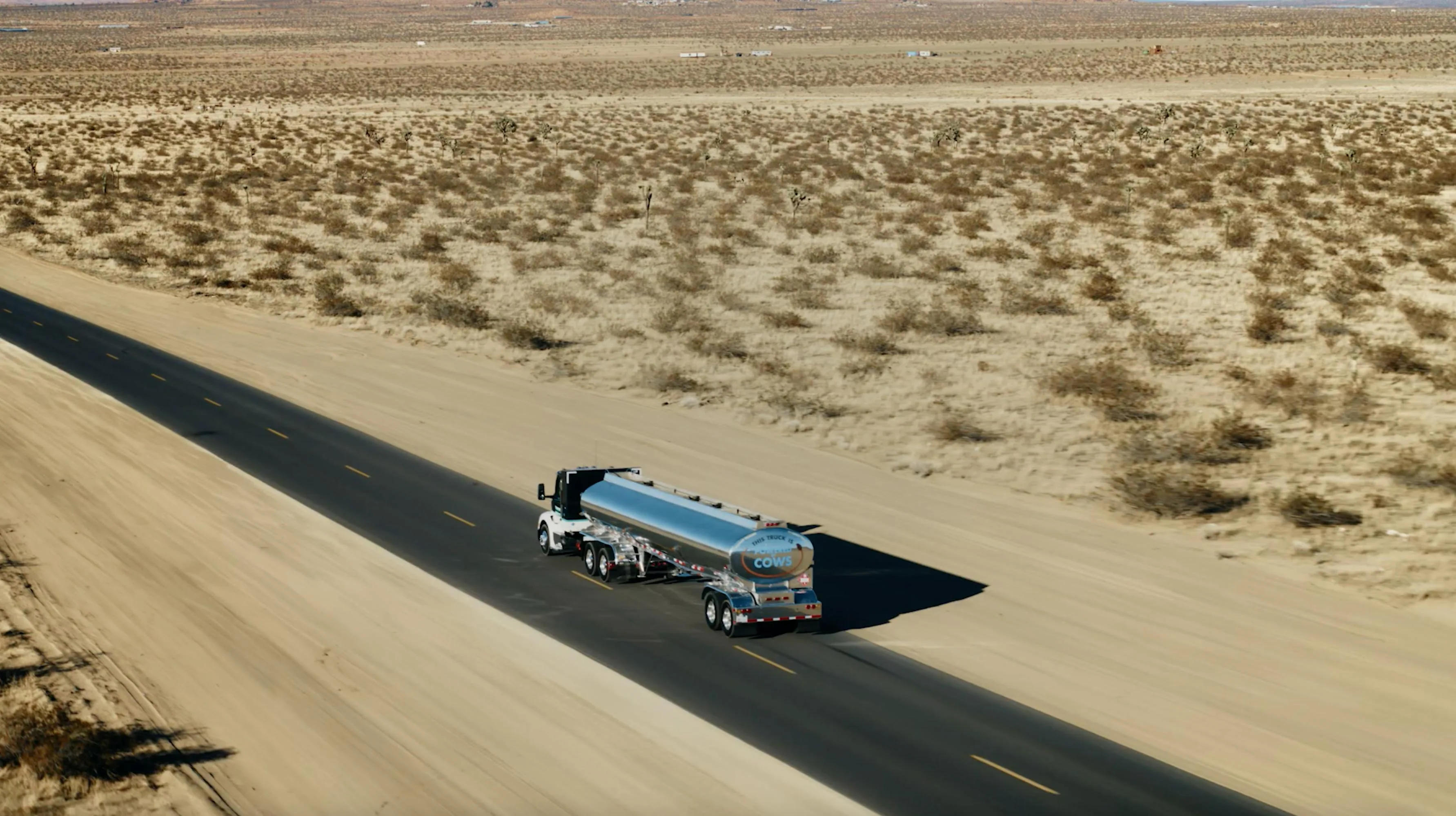 A tanker truck on the open highway at sunset