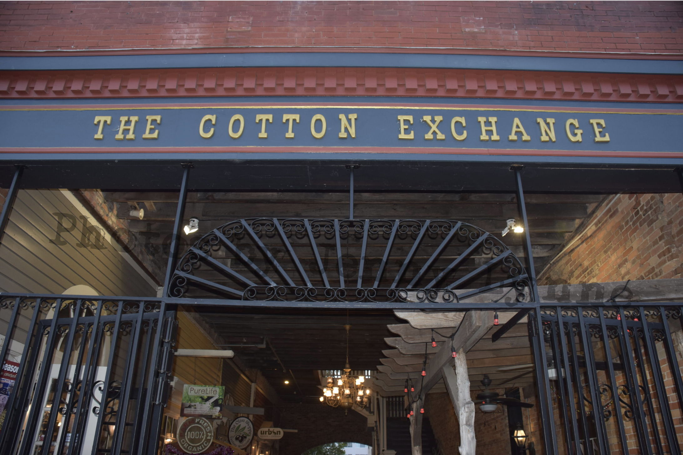 A camera lens and phone framing a colorful historic storefront