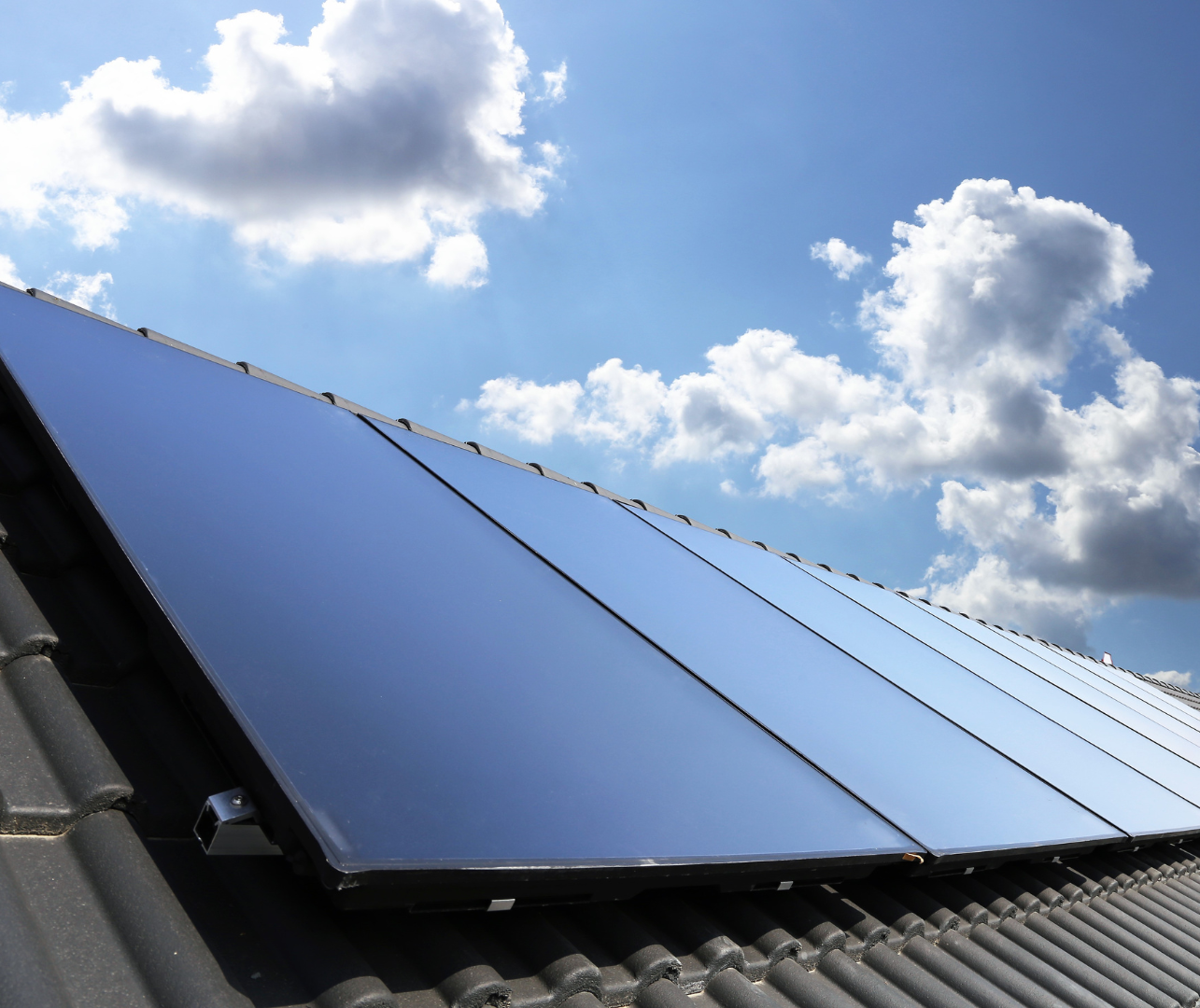 Roof-mounted solar PV panels against a blue sky