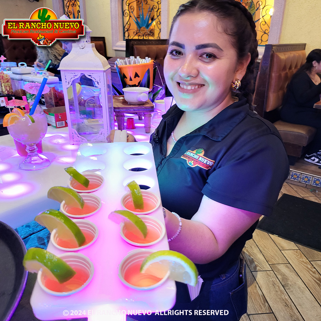 El Rancho Nuevo server presenting a flight of pink margaritas