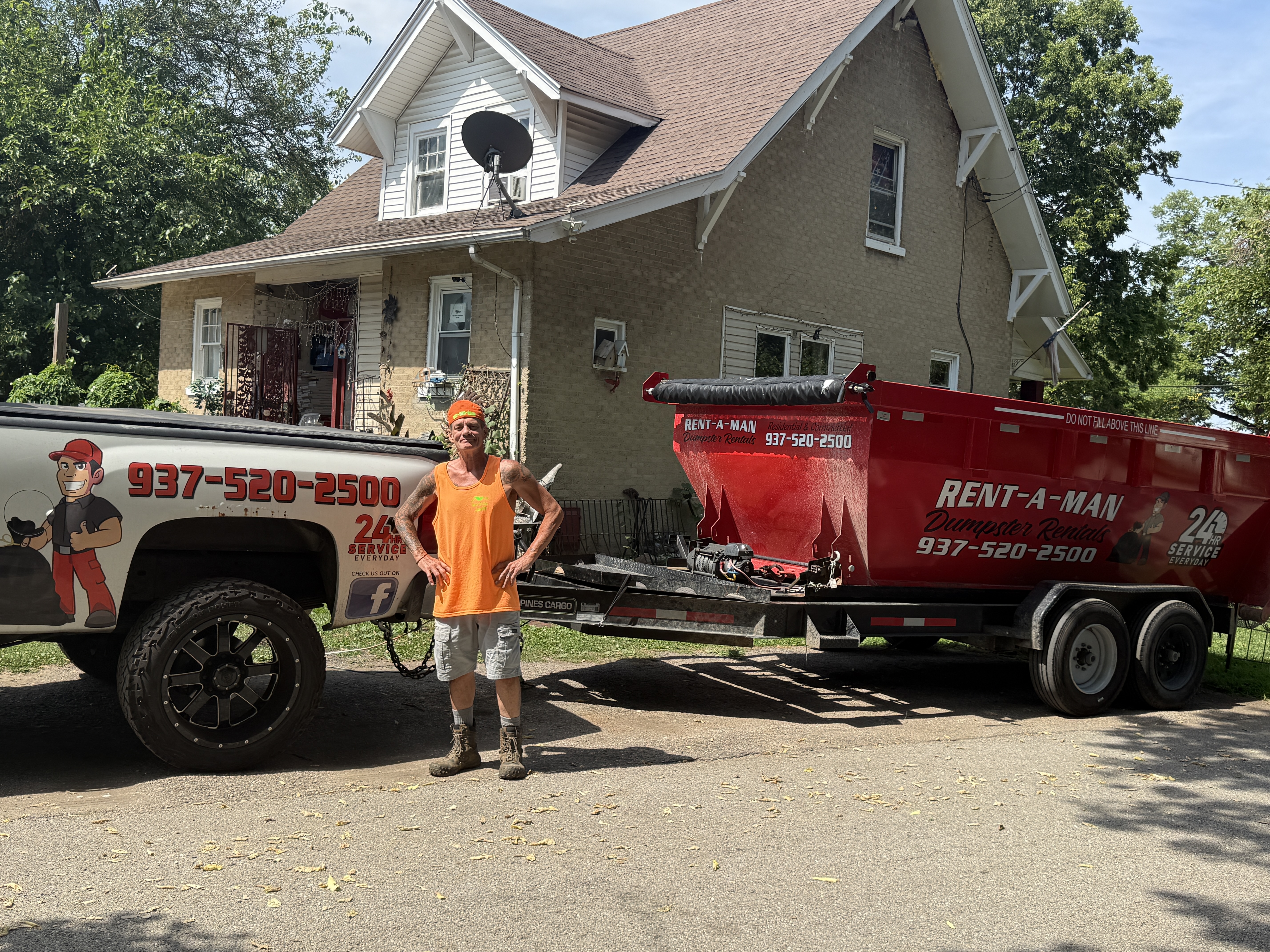 Owner of Rent-A-Man Dumpster Rentals with his truck and red dumpster trailer at a Dayton home