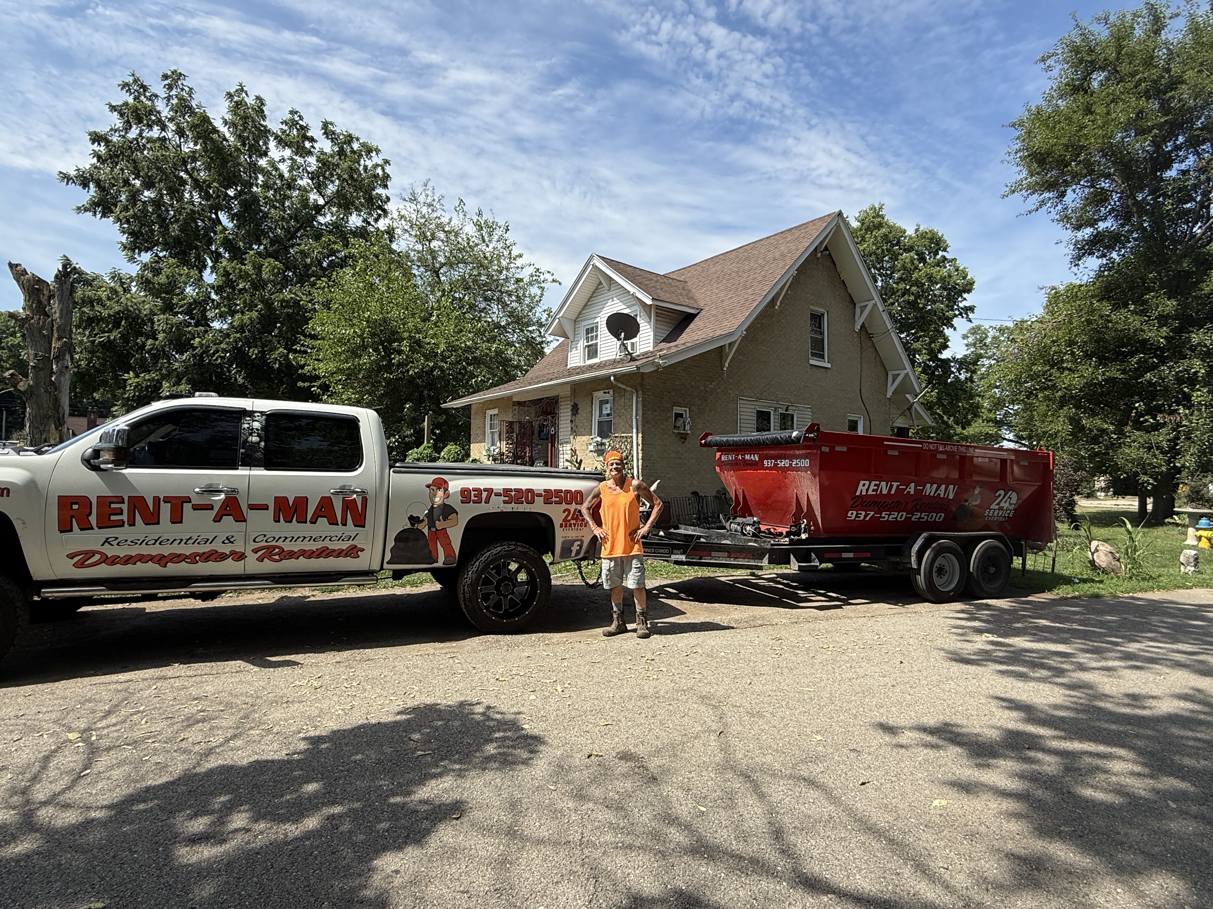 Rent-A-Man branded truck and red dumpster trailer delivering to a Dayton home