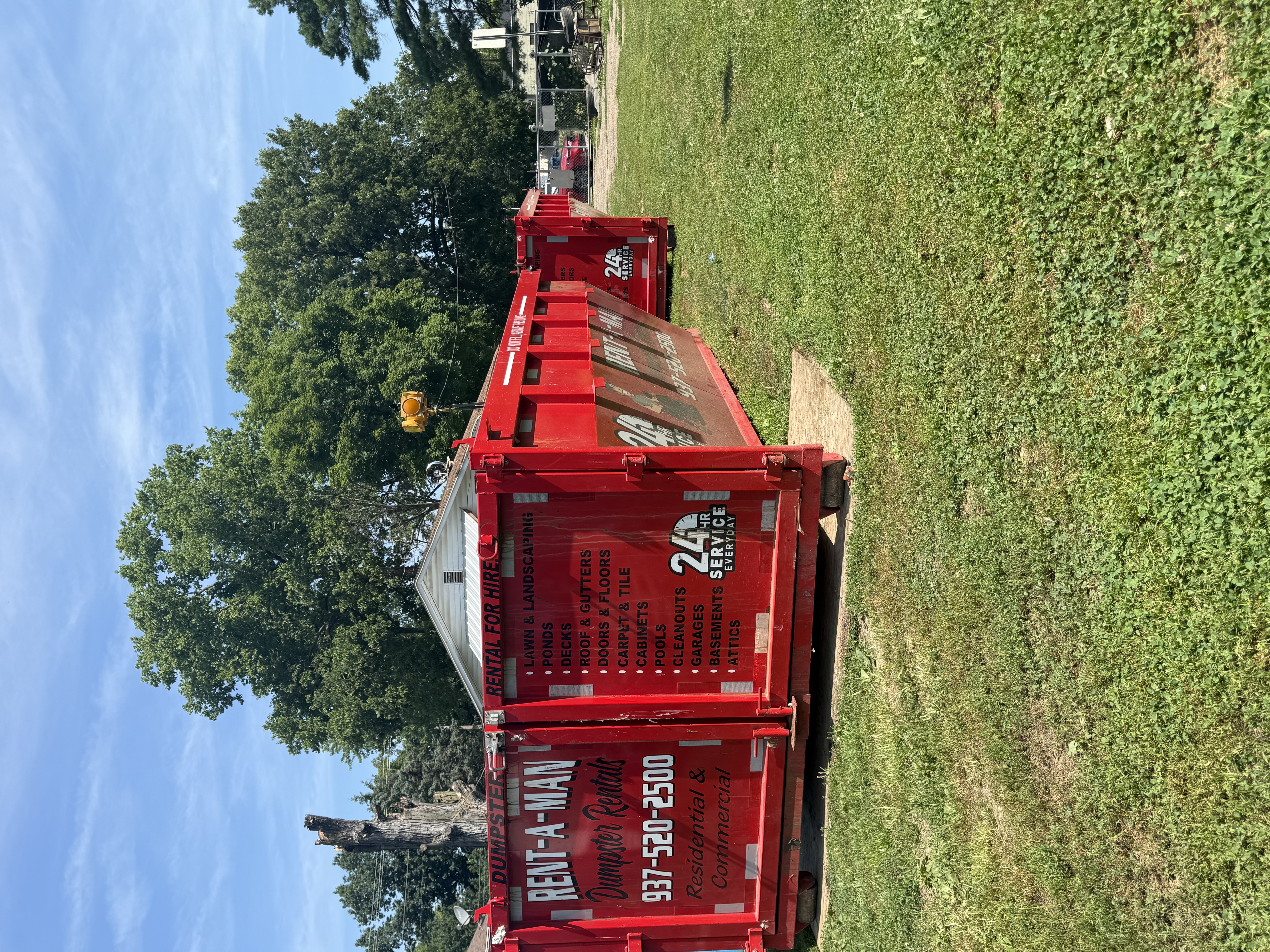 Red Rent-A-Man roll-off dumpsters with services list painted on the doors