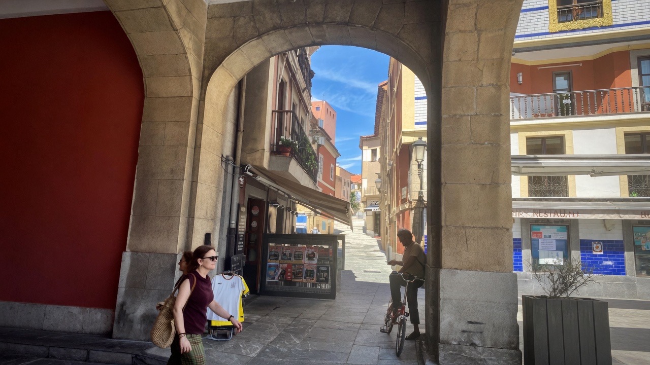 spanish arch with colorful homes beyond