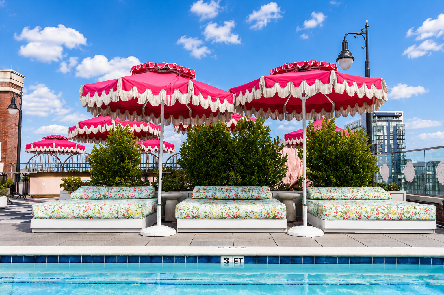 Fringed pink umbrellas over the rooftop pool