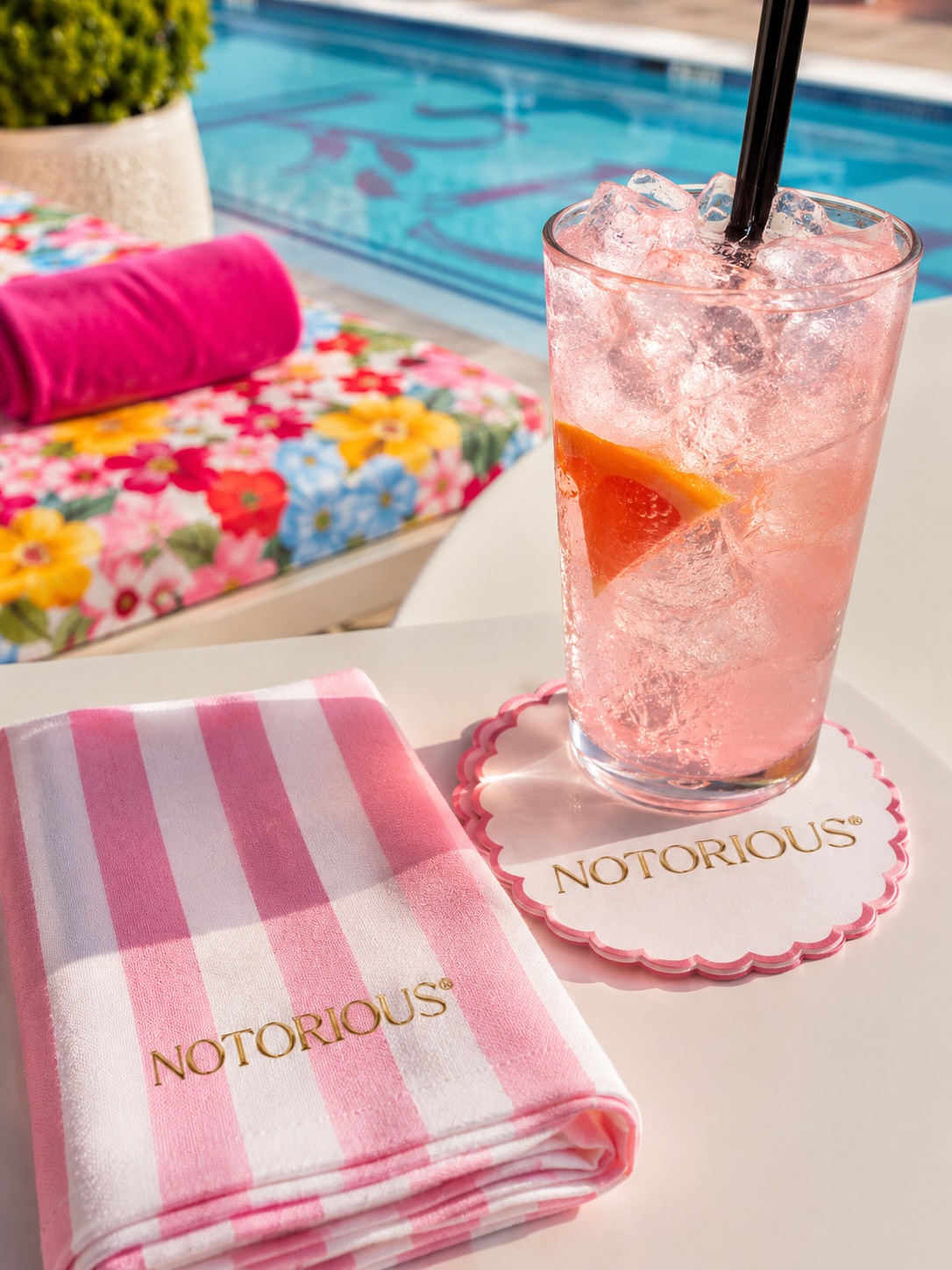 A Notorious pink cocktail and branded napkin poolside