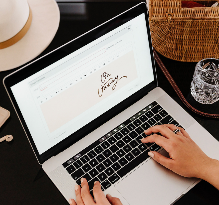 Laptop and desk styled in black and warm neutral tones