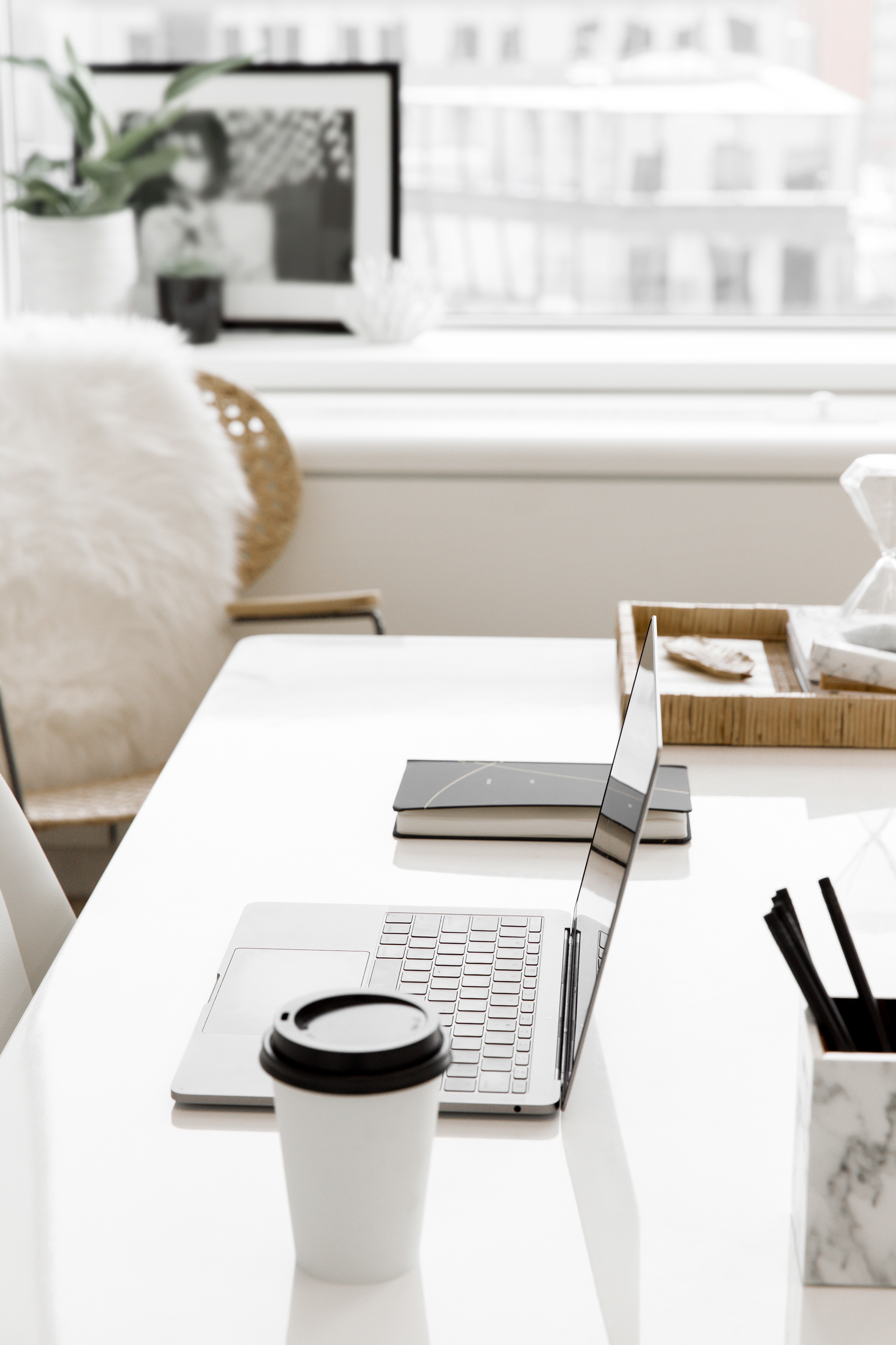 Minimal white workspace with laptop and coffee