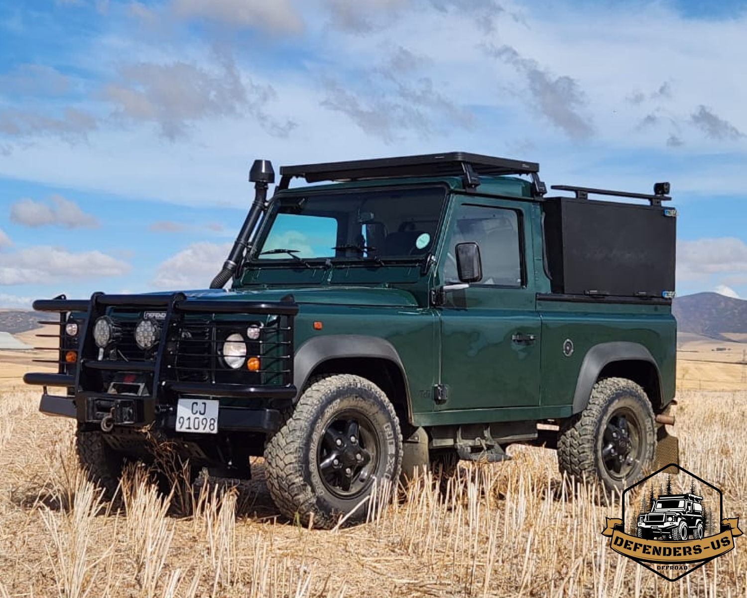 Olive-green classic land rover defender for sale parked on a driveway