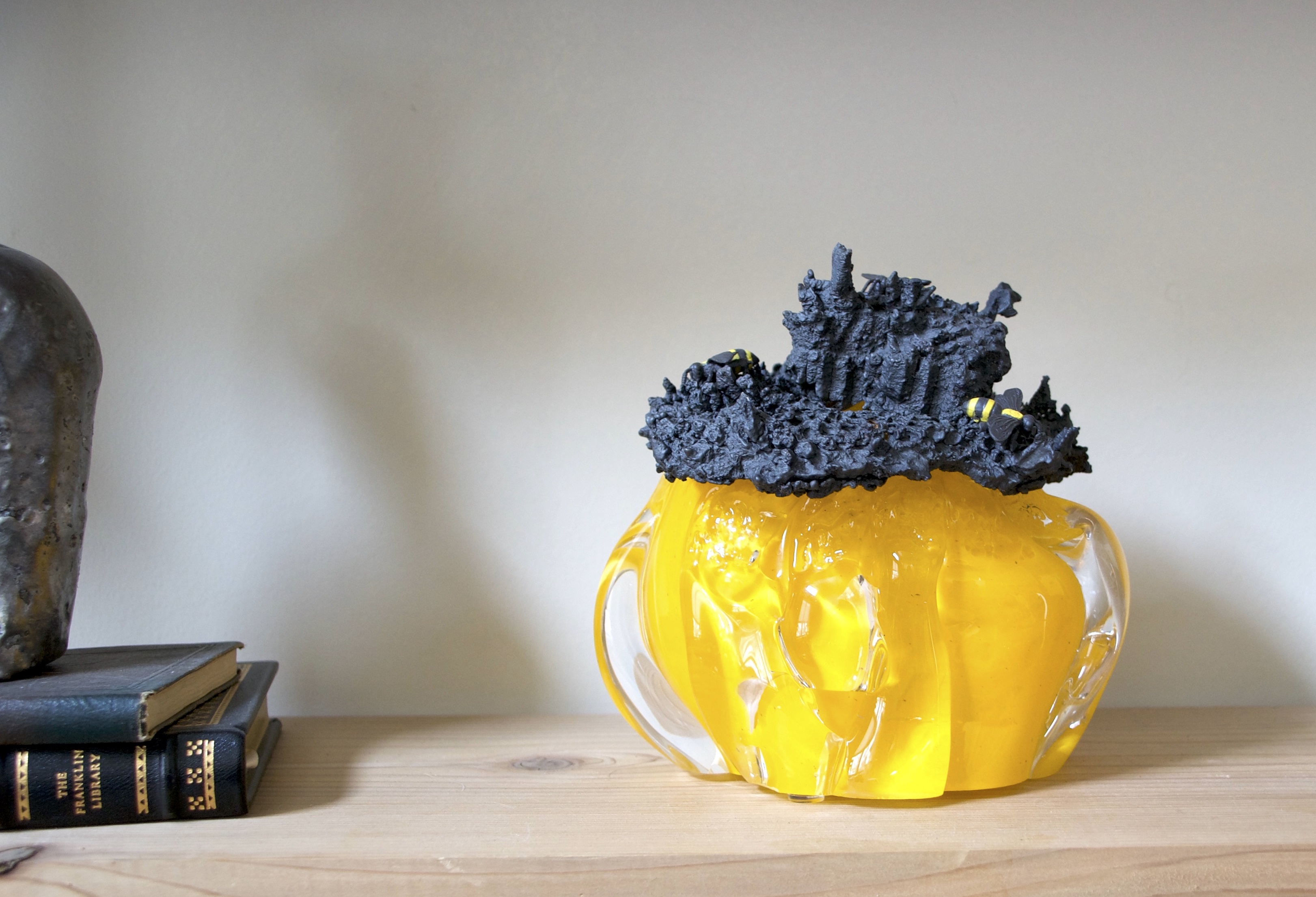 blown golden glass to look like honey pouring out of the cast iron bees nest that sits upon the glass