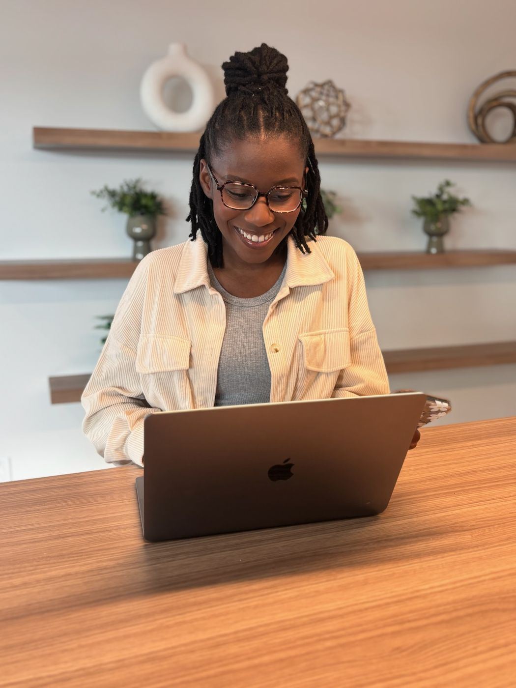 Wildiah Edouard smiling while working on her laptop