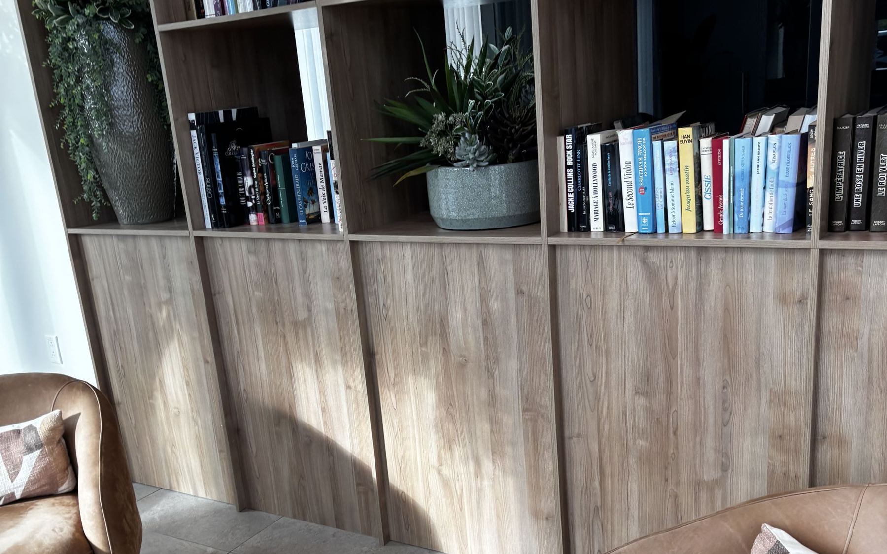 A bright reading lounge with bookshelves and leather chairs