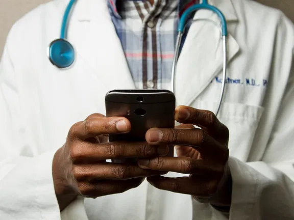 A healthcare professional using a smartphone to manage clinic appointments A healthcare professional using a smartphone to manage clinic appointments