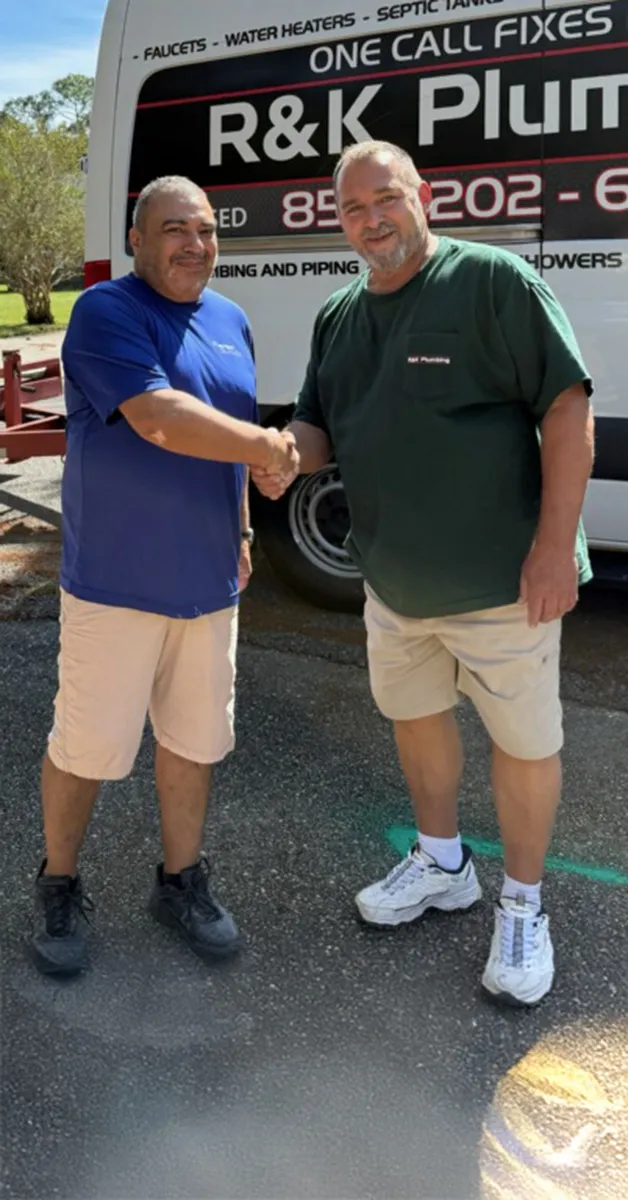 Rob from R&K Plumbing shaking hands with a satisfied Pensacola customer