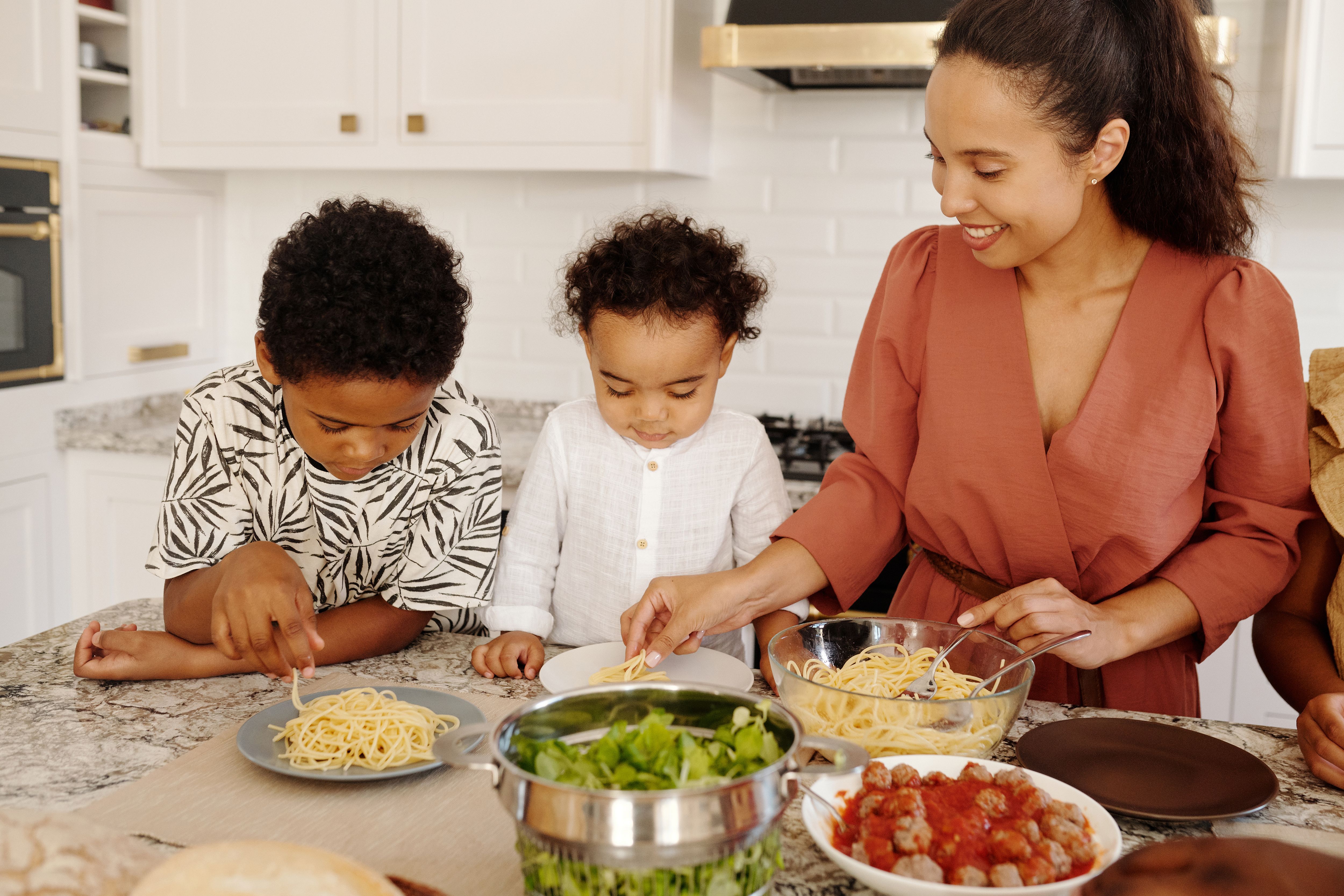 Parent spending time with children while preparing dinner Parent spending time with children while preparing dinner