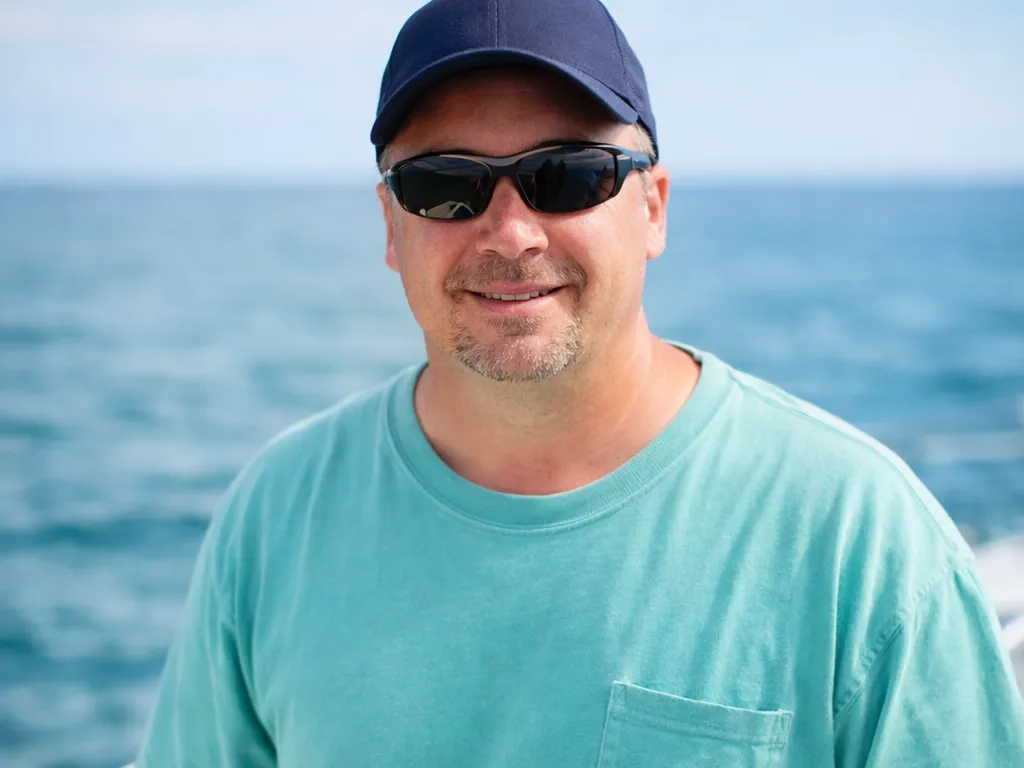 Captain on deck with trolling rods, RingMaster Charters—offshore fishing near Pompano Beach, FL.