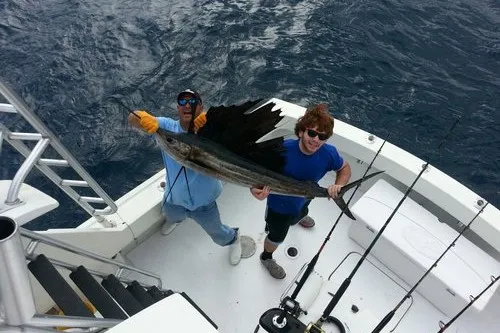 Happy anglers holding a big fish on a RingMaster Charters half-day trip off Pompano Beach, Florida.
