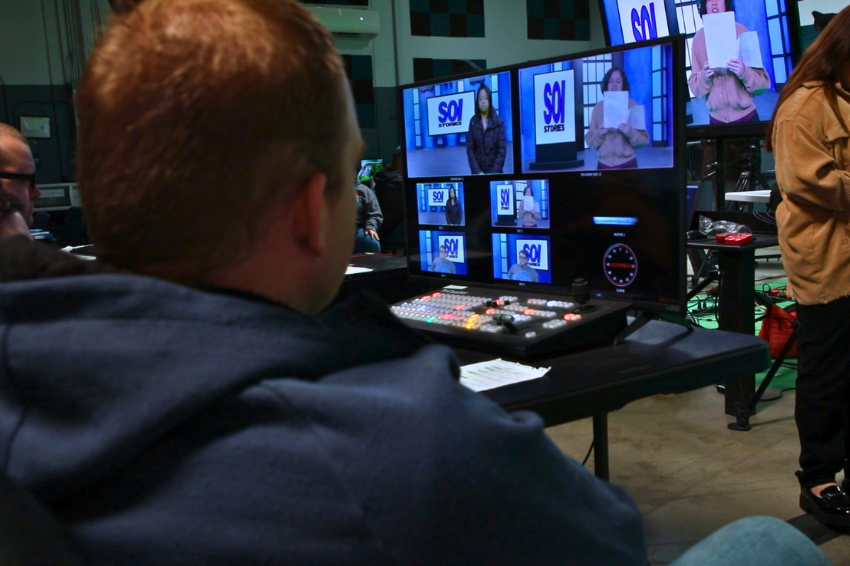 Students working together during a documentary filmmaking session using professional cameras and audio equipment in a hands-on media production environment.