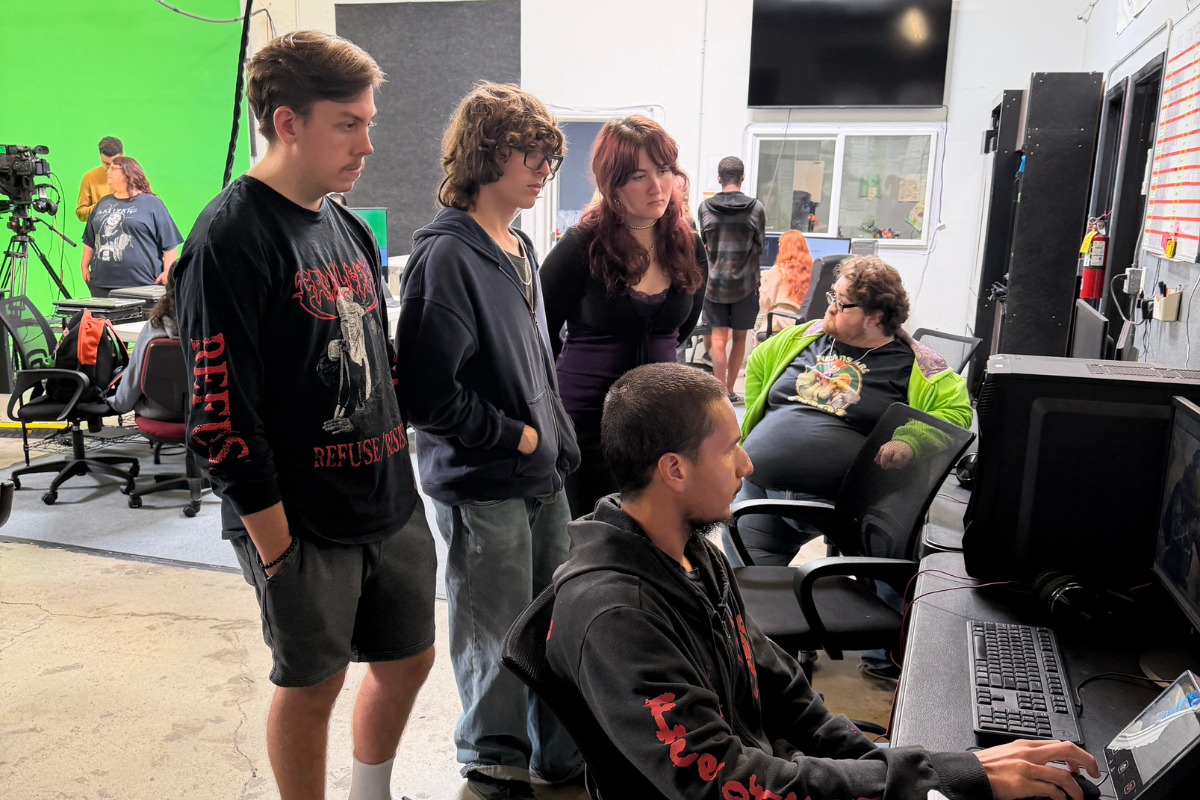 Students working together during a documentary filmmaking session using professional cameras and audio equipment in a hands-on media production environment.