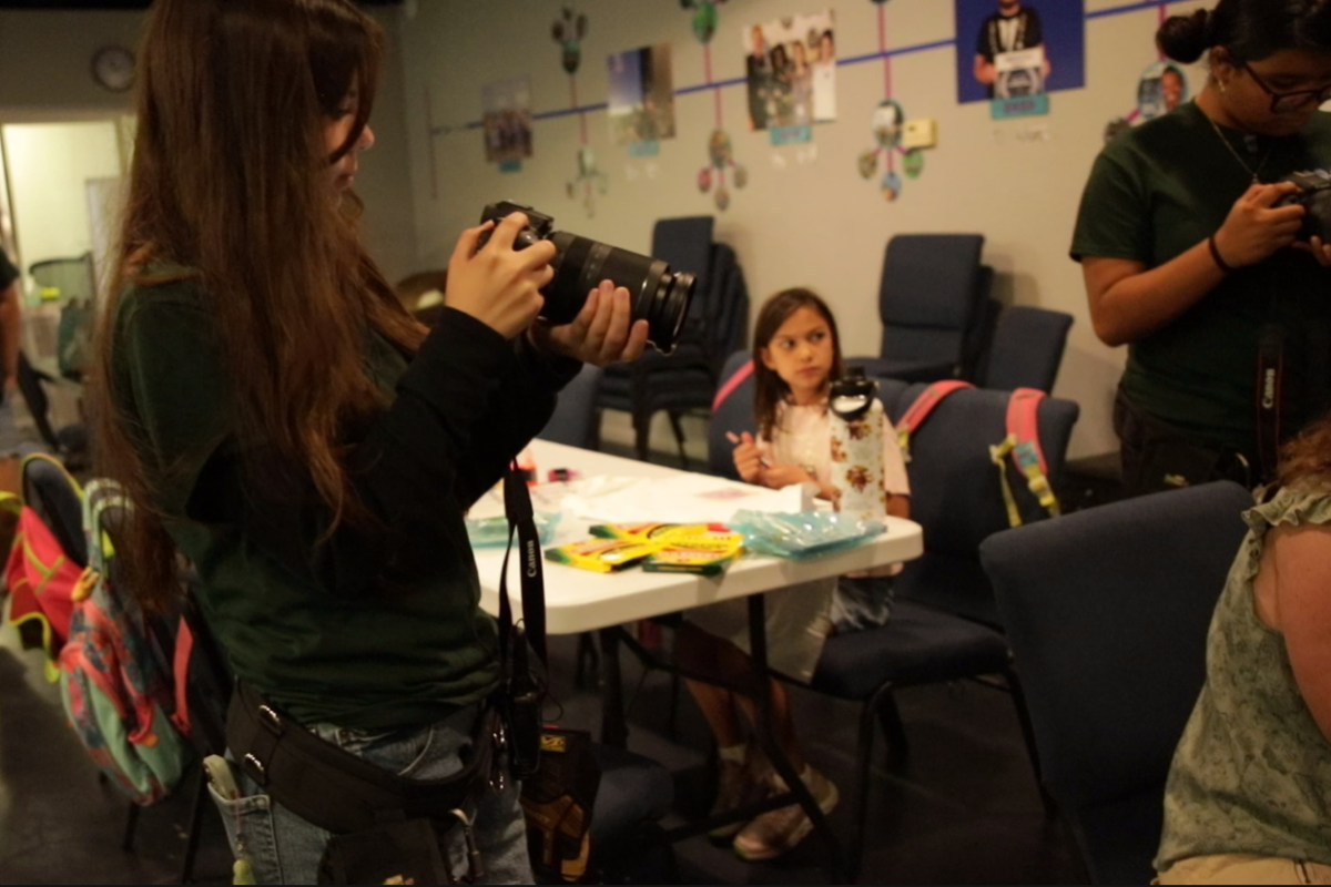 Students working together during a documentary filmmaking session using professional cameras and audio equipment in a hands-on media production environment.
