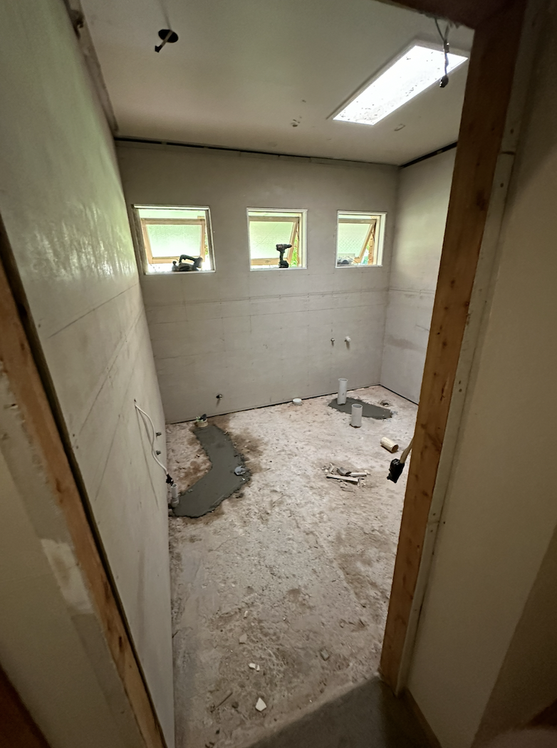 Main view of the renovated bathroom with freestanding bath and grey tiles in Dubbo