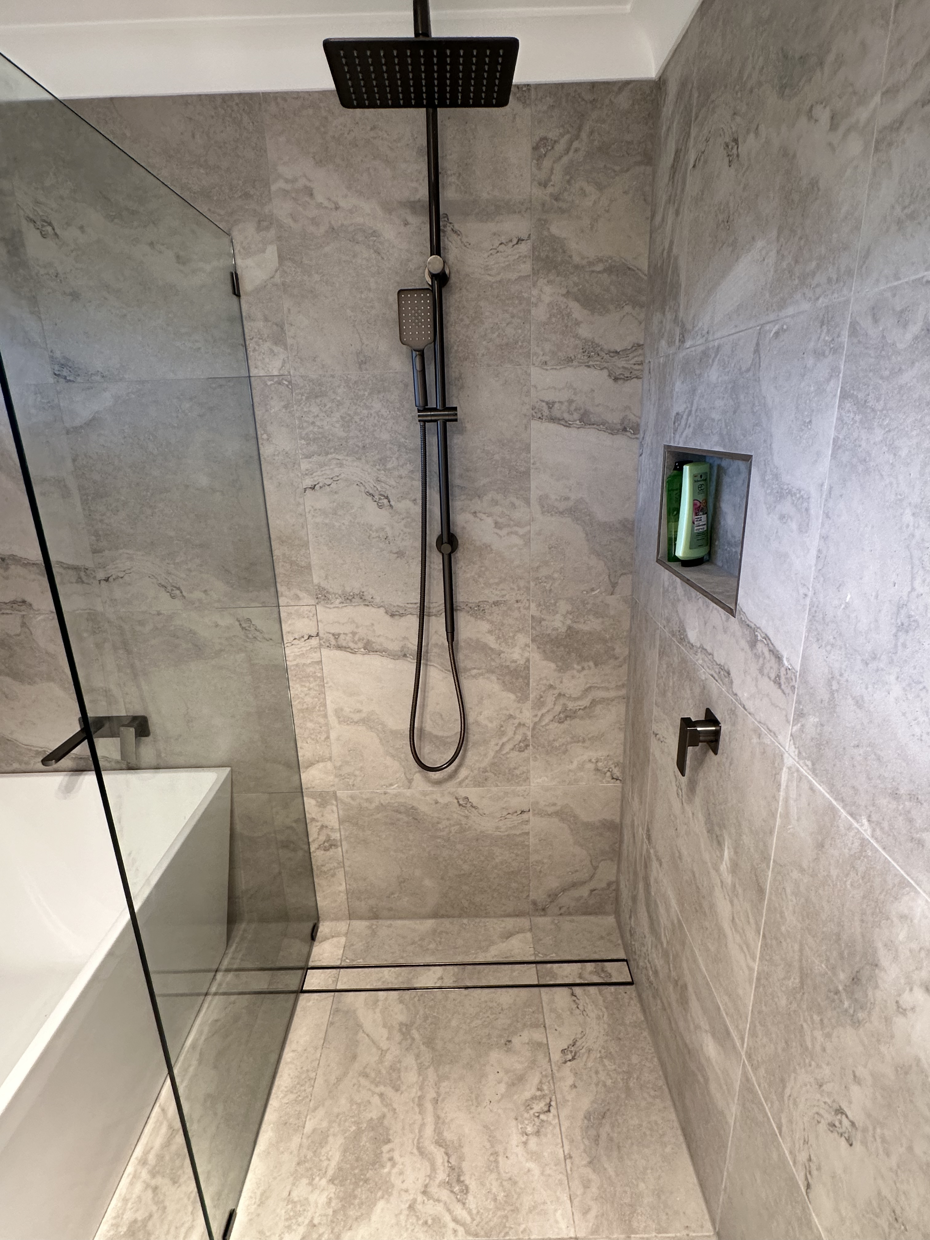 Marble-look wall and floor tile detailing in the Trangie bathroom