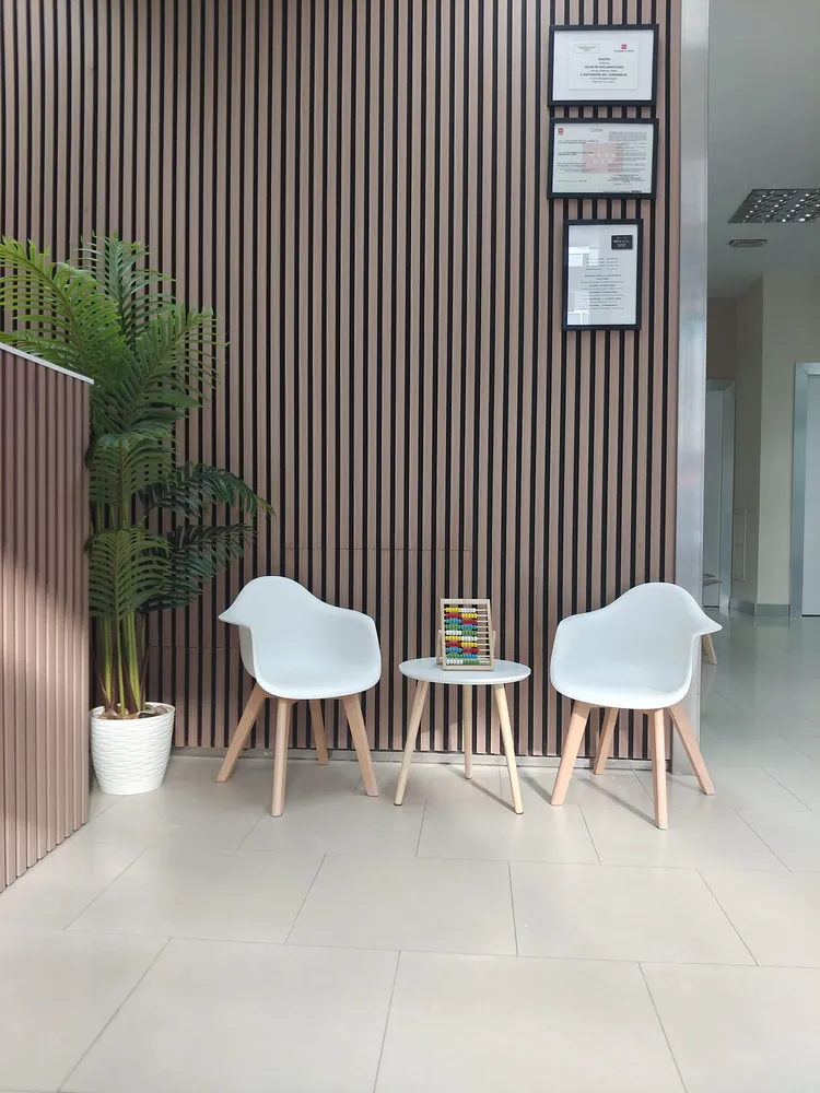 Sala de espera de My Dental, con la pared de listones de madera