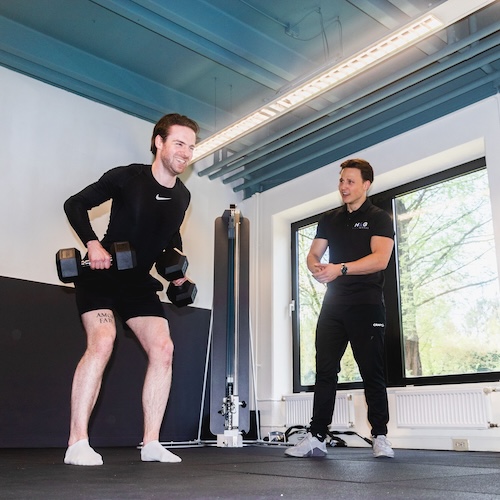 Personal trainer helpt met buikoefening