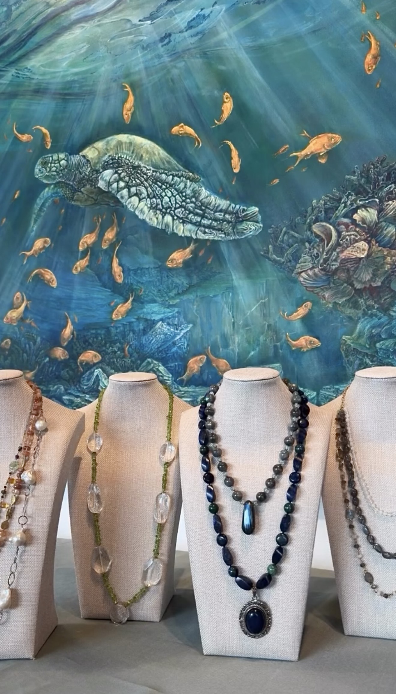 gemstone jewelry displayed alongside fine art inside create gallery and frames