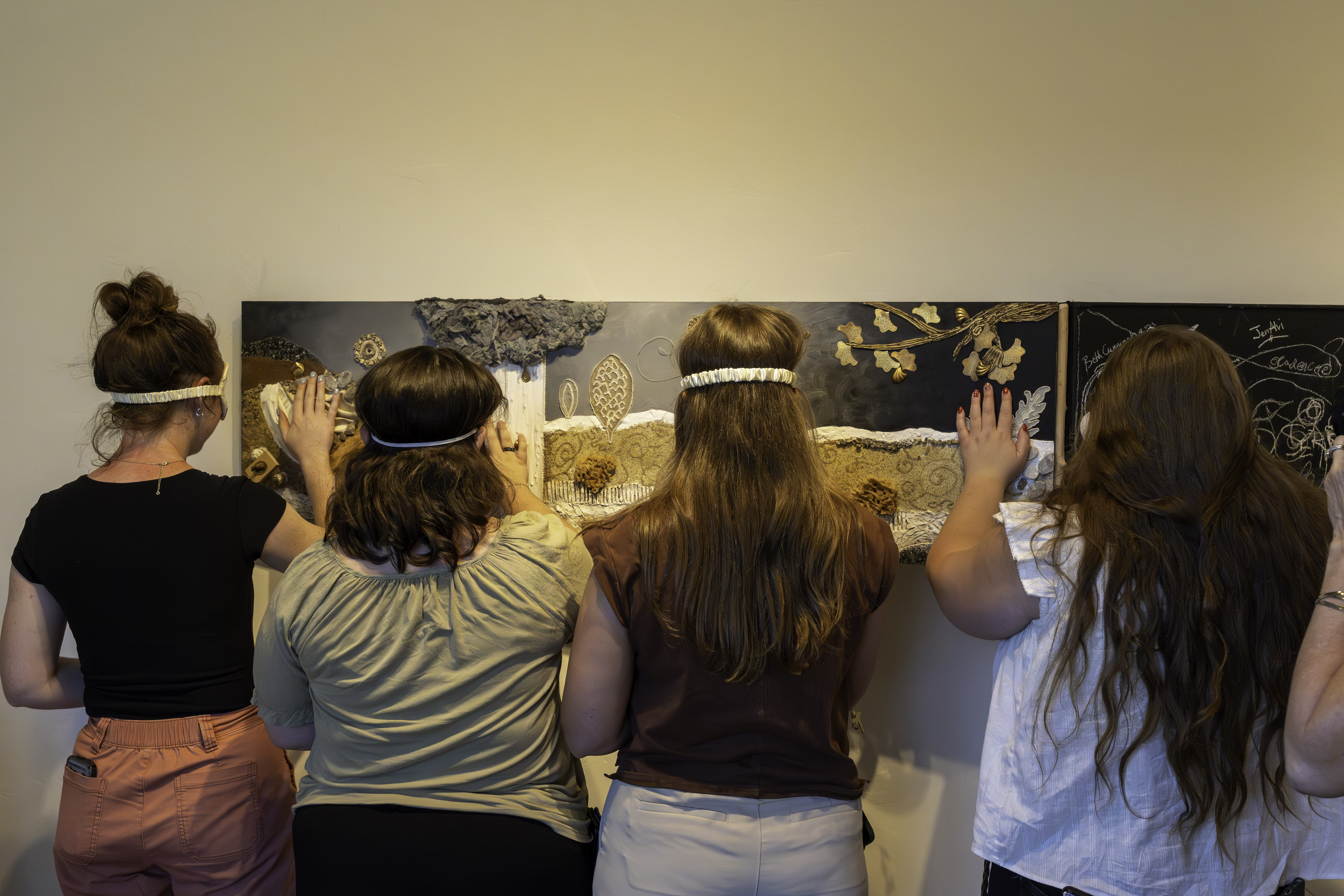 sighted visitors participating in the minds eye exhibition blindfolded during sight unseen at create gallery and frames sighted visitors participating in the minds eye exhibition blindfolded during sight unseen at create gallery and frames