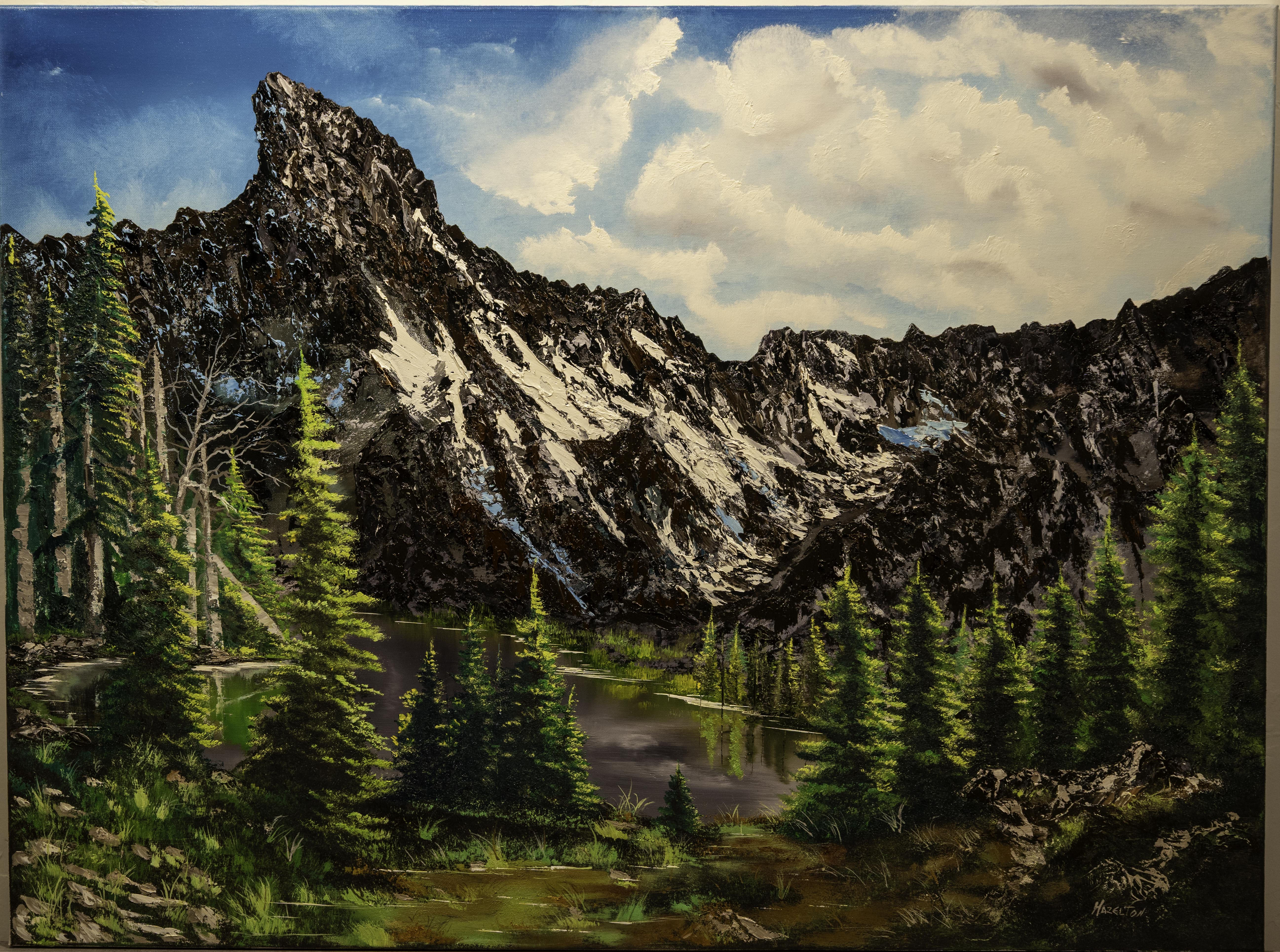 Mountain landscape painting showing rugged peaks, evergreen trees, and a peaceful alpine lake under a bright sky.