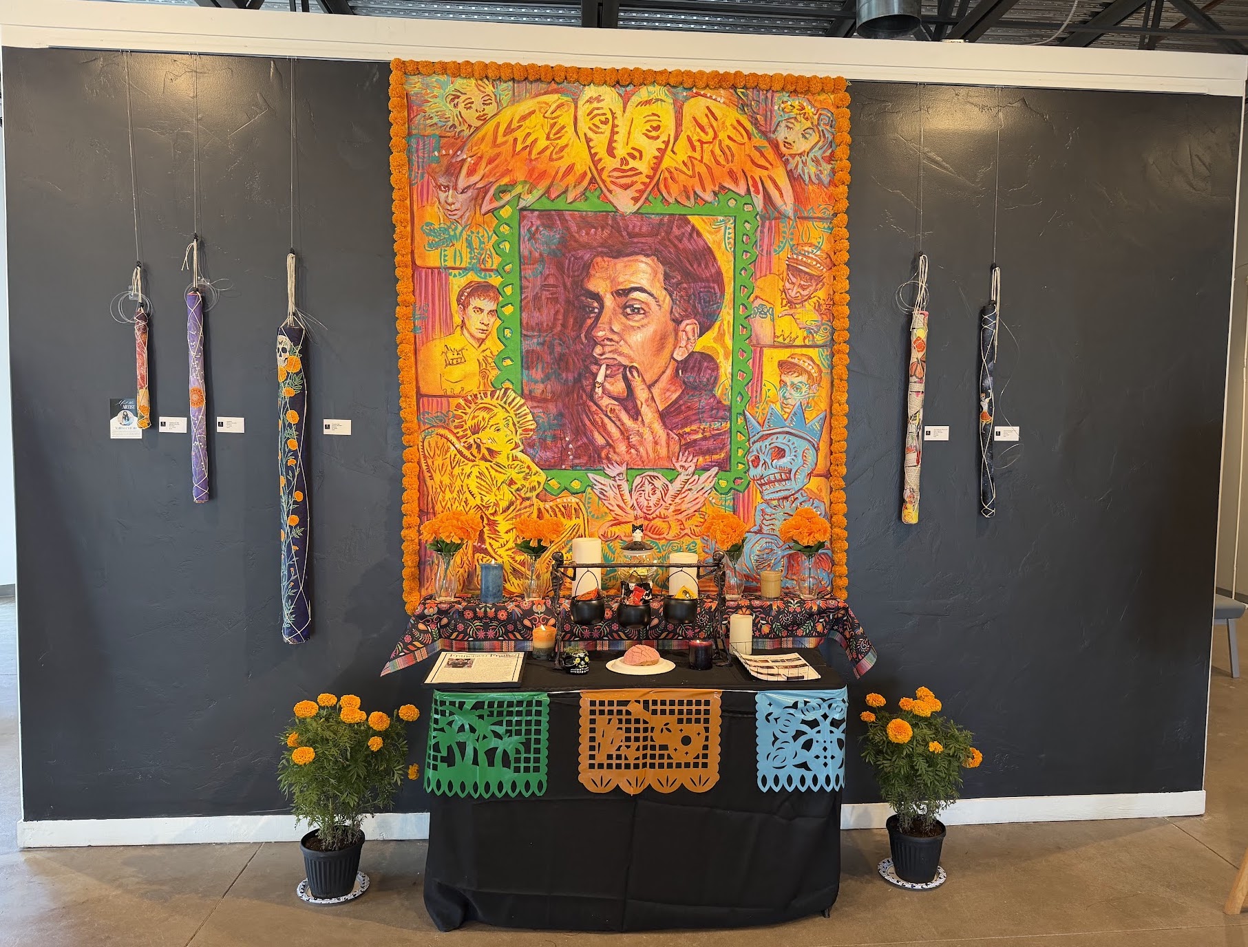 Colorful marigolds, papel picado, and Día de los Muertos decorations displayed inside Create Gallery and Frames. Colorful marigolds, papel picado, and Día de los Muertos decorations displayed inside Create Gallery and Frames.